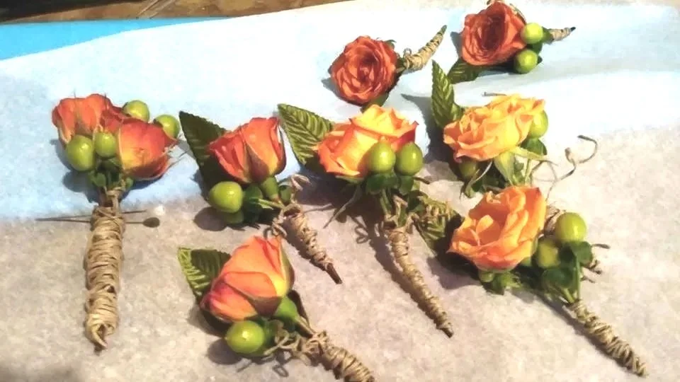 Artificial roses with wrapped stems, arranged on a surface.