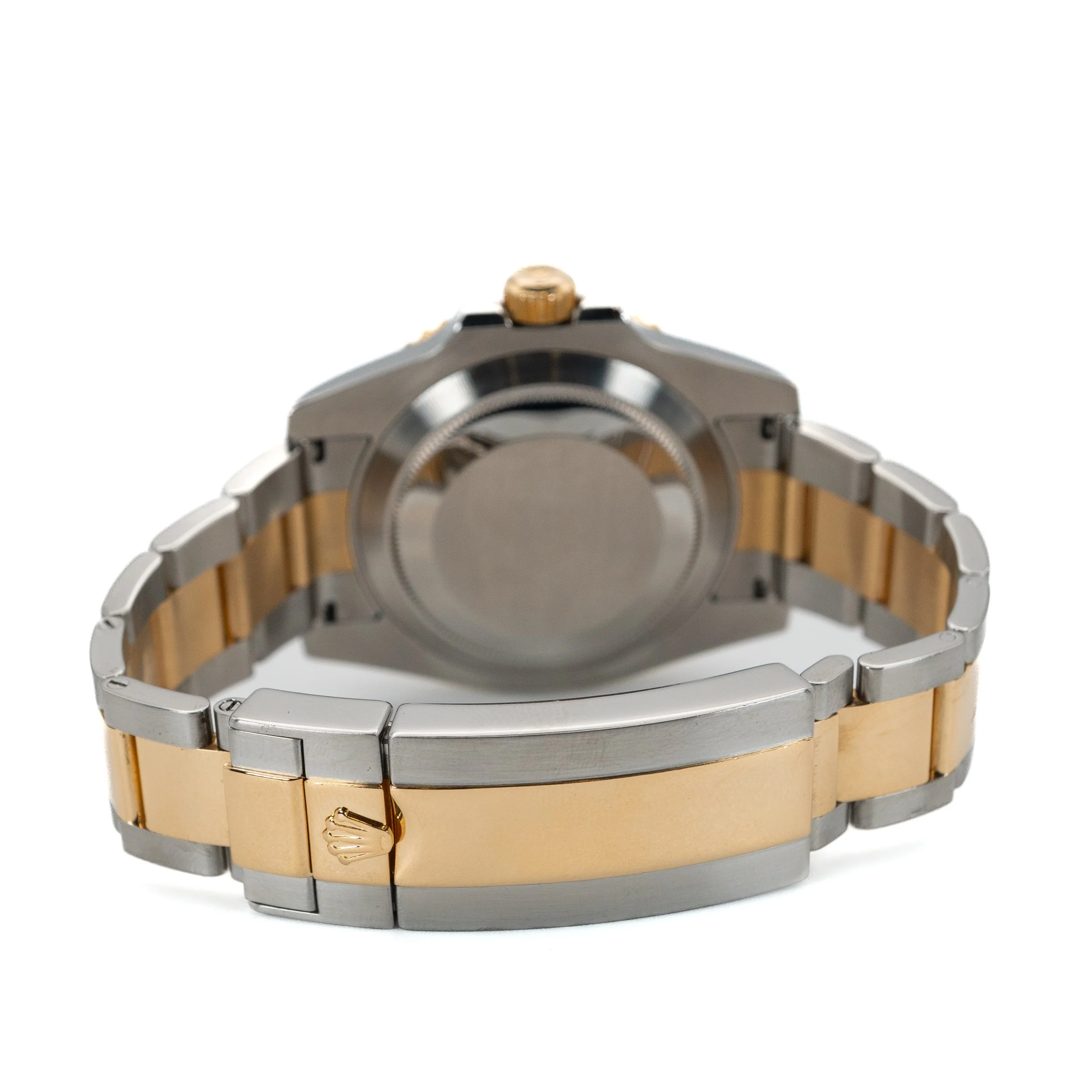 Two-tone metal wristwatch with gold and silver links, viewed from the back showing the case and bracelet.