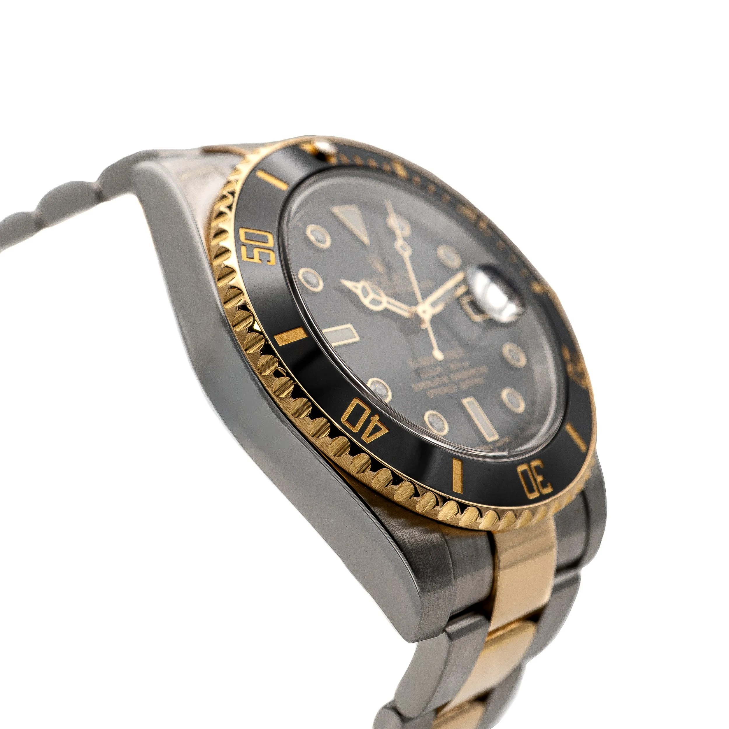 Close-up of a luxury wristwatch with a black and gold bezel, black dial, and a two-tone metal band.