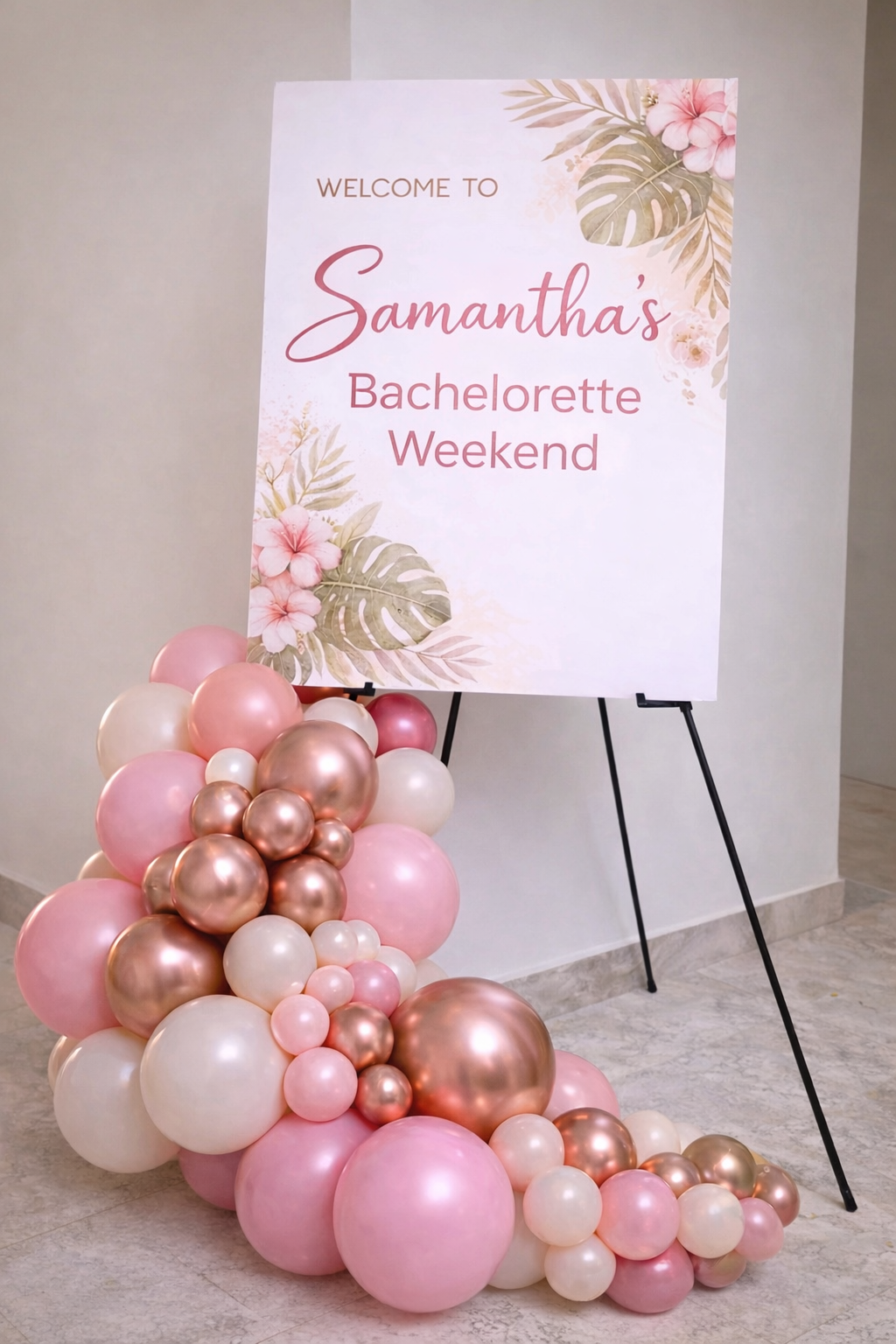 A sign welcoming guests to Samantha's Bachelorette Weekend, decorated with pink and gold balloons and a floral design.