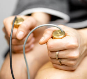 Person holding a reflex hammer with both hands, used for neurological examinations.