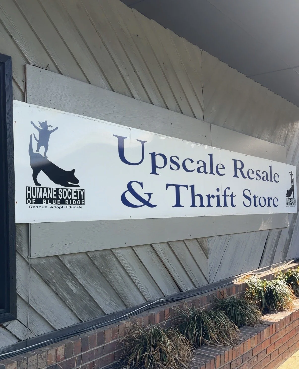 Sign for Upscale Resale & Thrift Store with Humane Society of Blue Ridge logo and text.