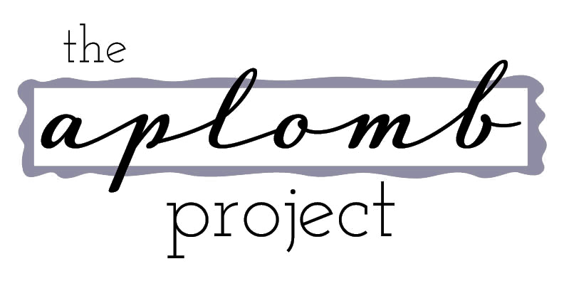 Logo for The Applomb Project with stylized black script for 'applomb' on purple background, and 'the' and 'project' in smaller black text above and below.