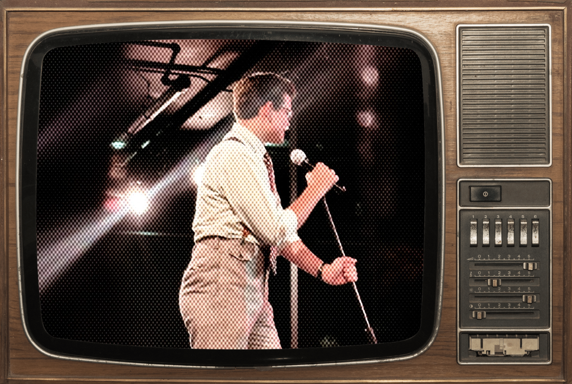 Vintage television showing a woman singing into a microphone on stage with bright spotlights.