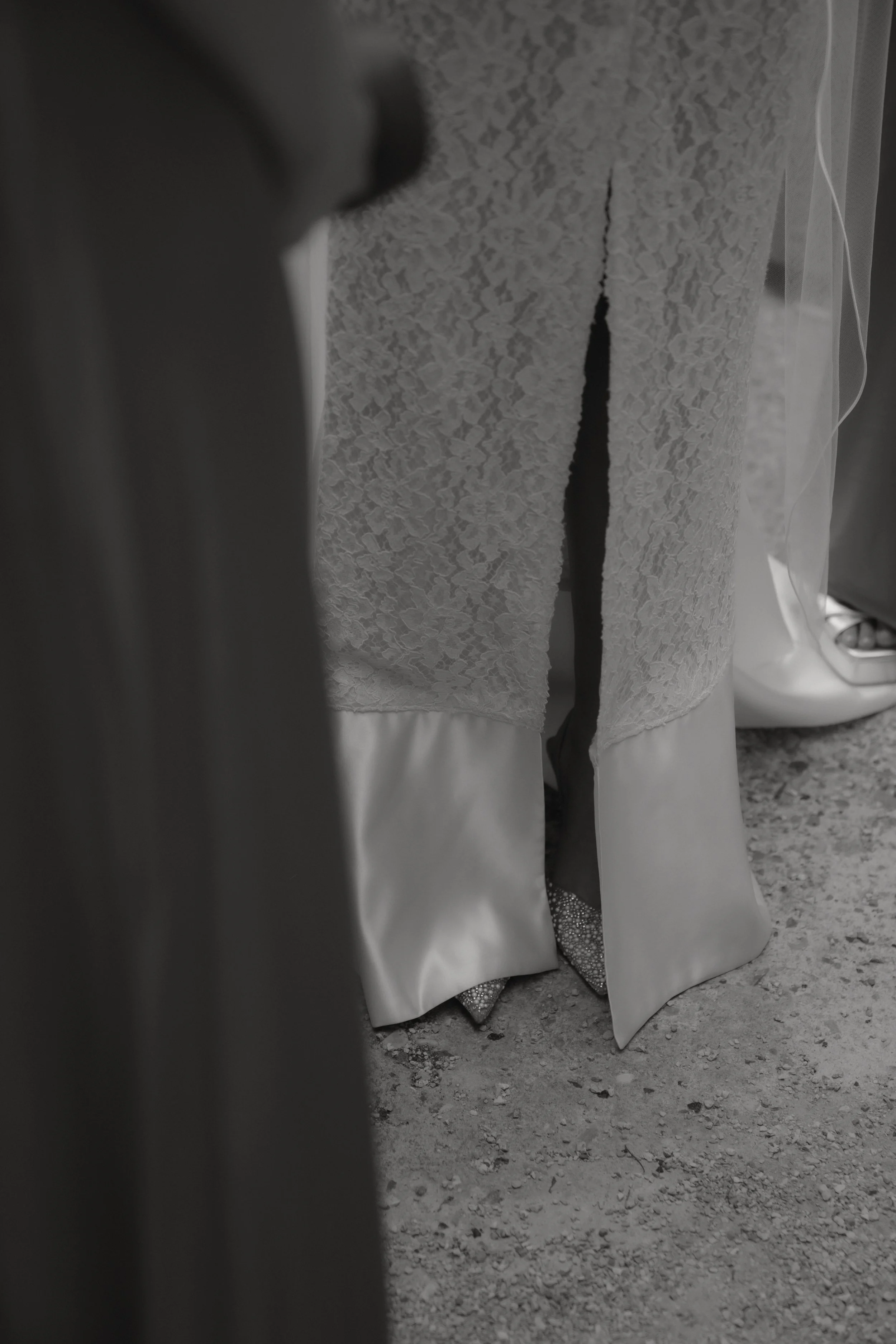 Nahaufnahme eines Brautkleids mit offenem Schlitz an den Beinen, das auf dem Boden steht.