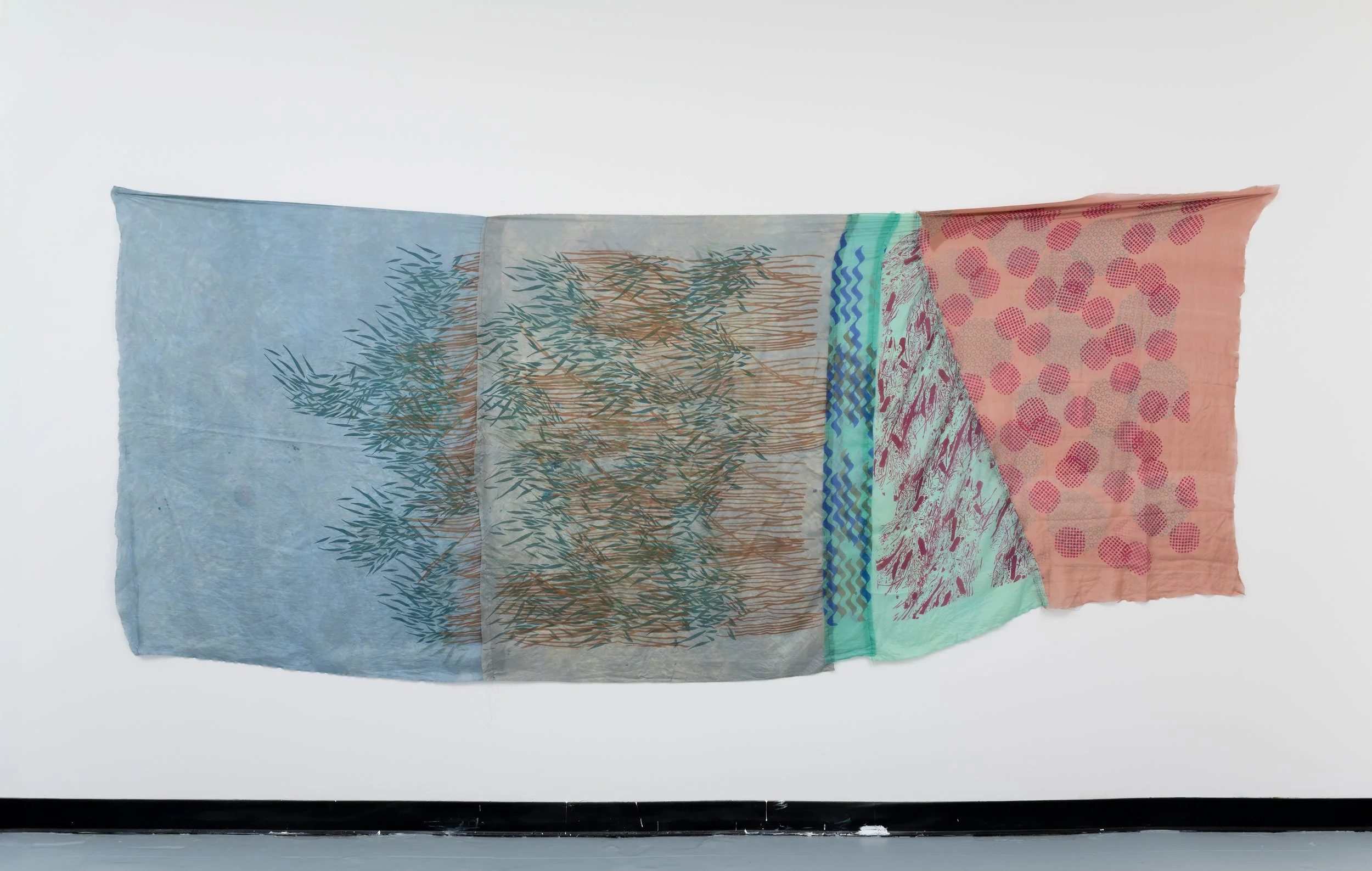 Colorful, translucent textile hanging on a wall with abstract patterns and designs.