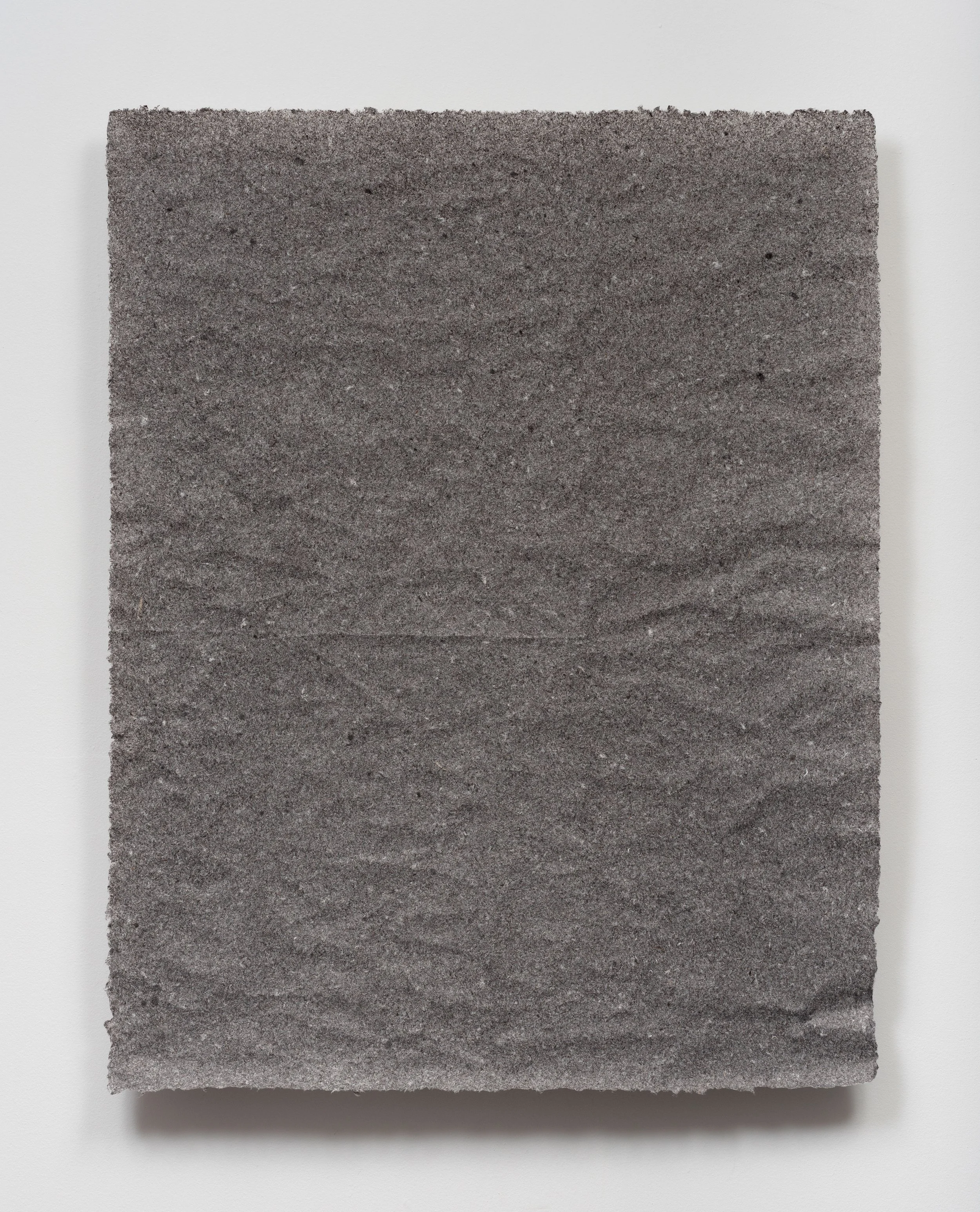 Close-up of a gray sandpaper sheet with rough texture against a white background.