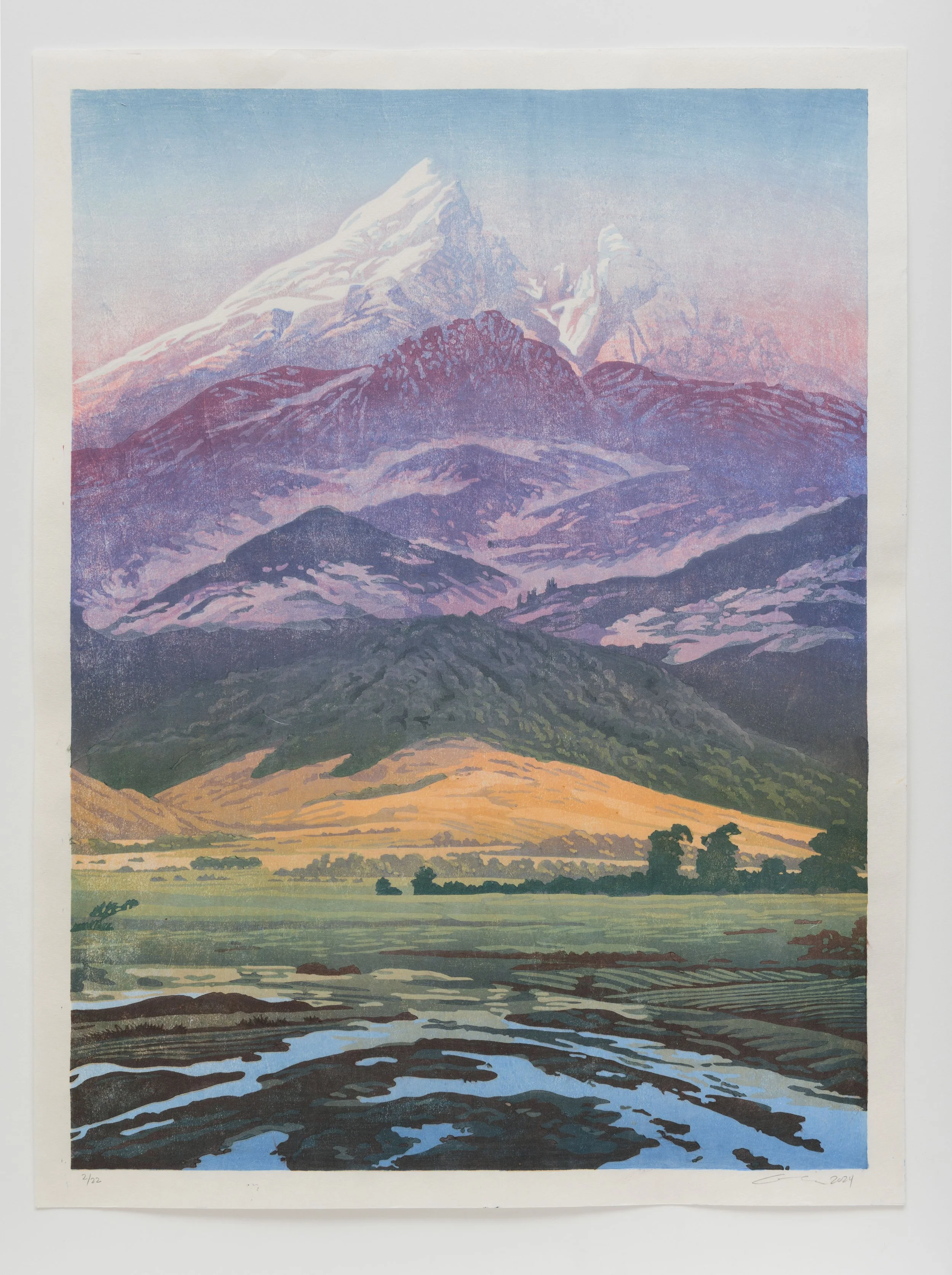 A landscape painting of mountains with snow caps, rolling hills, a river in the foreground, and a sky with gradient colors.