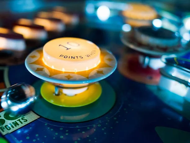 Close-up of a pinball machine's yellow score wheel displaying 10 points with the text 'POINTS WIN' visible underneath.