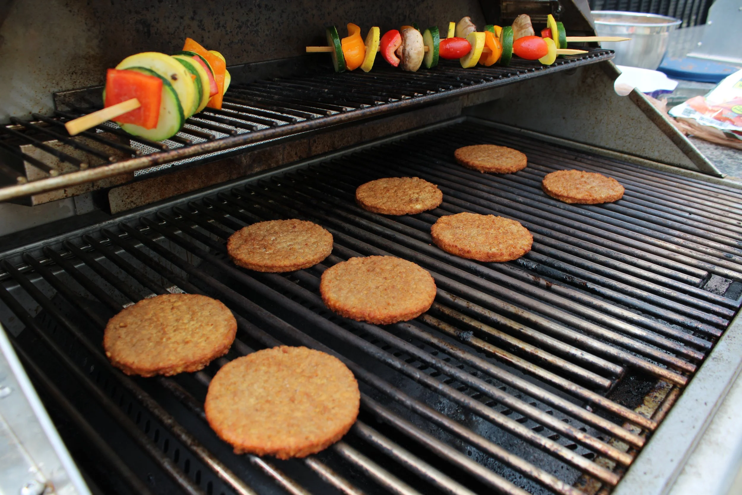 Veggie burgers and vegetable kebabs on the grill at the Triangle QuestHouse Canada Day cookout