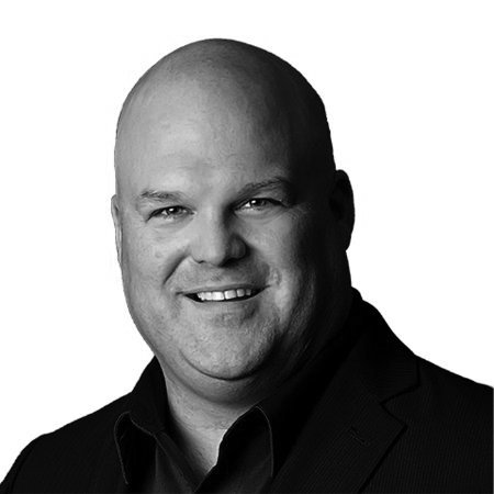 Black and white portrait of a bald man in a suit smiling