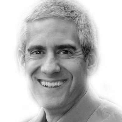 Black and white portrait of a smiling man with short, light hair.