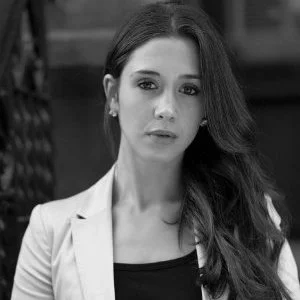 Black and white portrait of a woman with long dark hair, wearing a blazer and top