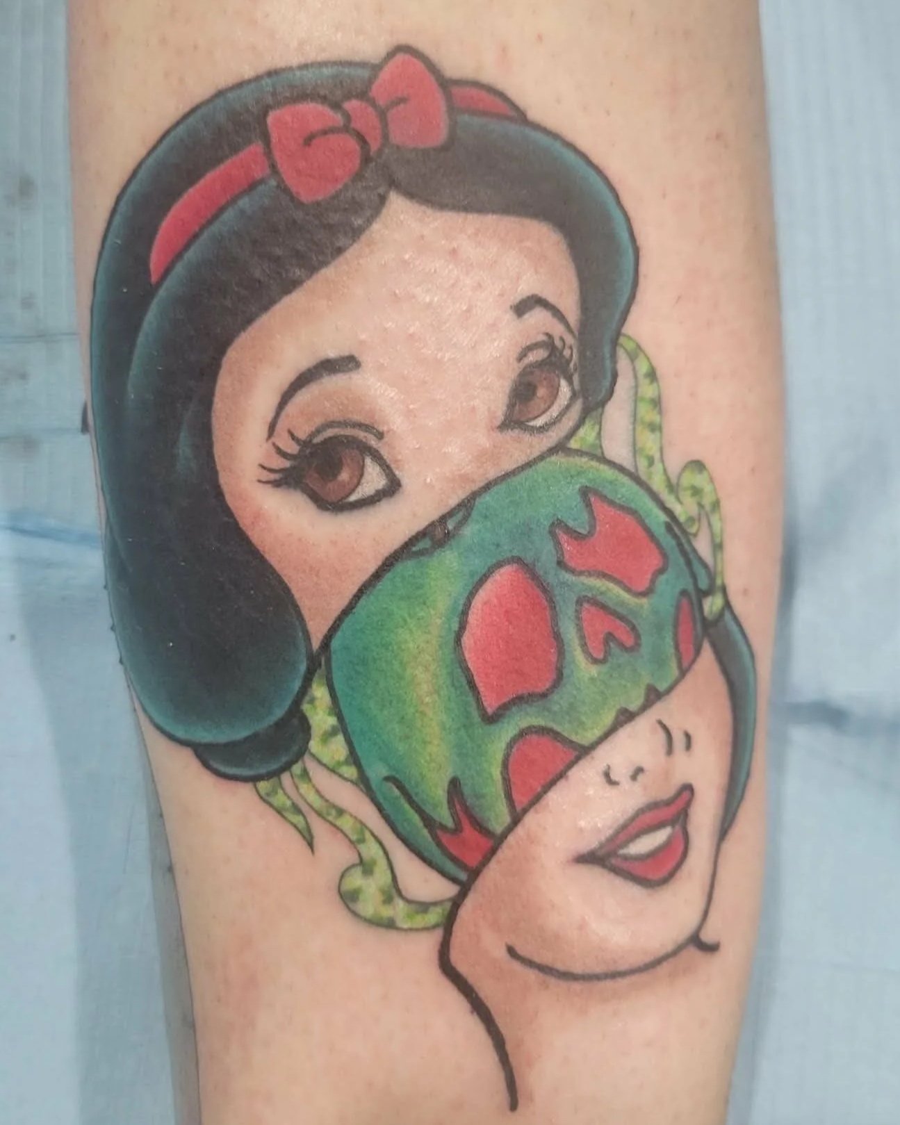 Tattoo of a cartoon-style Snow White character  a colorful poison apple.