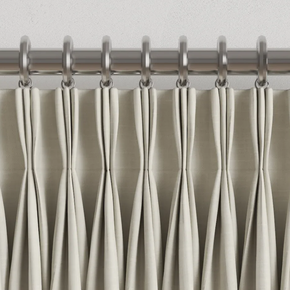 White shower curtain hanging from a metal rod with metal rings.