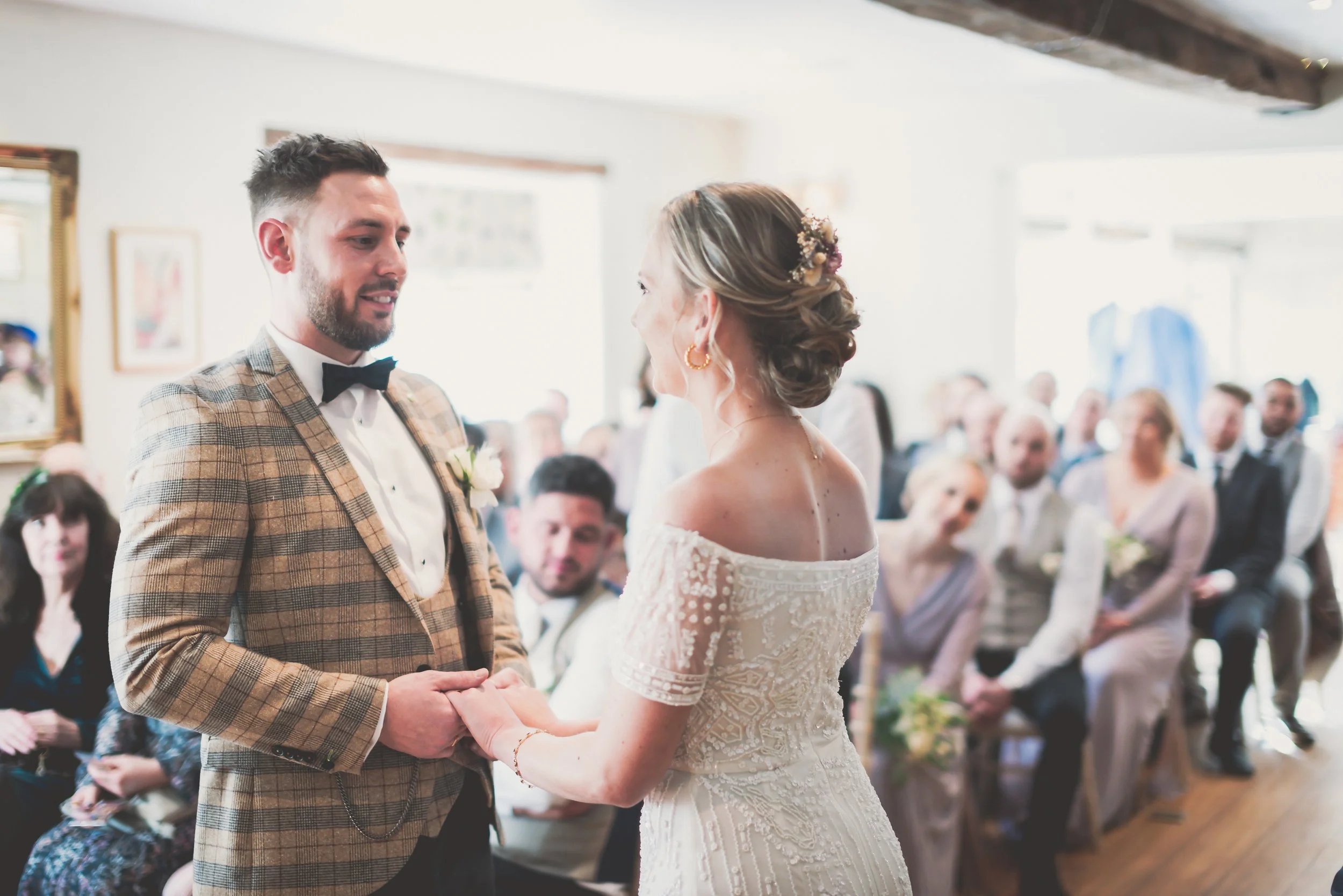 Bride and groom holding hands at top of aisle before saying their vows at Moonraker Hotel in Bradford on Avon