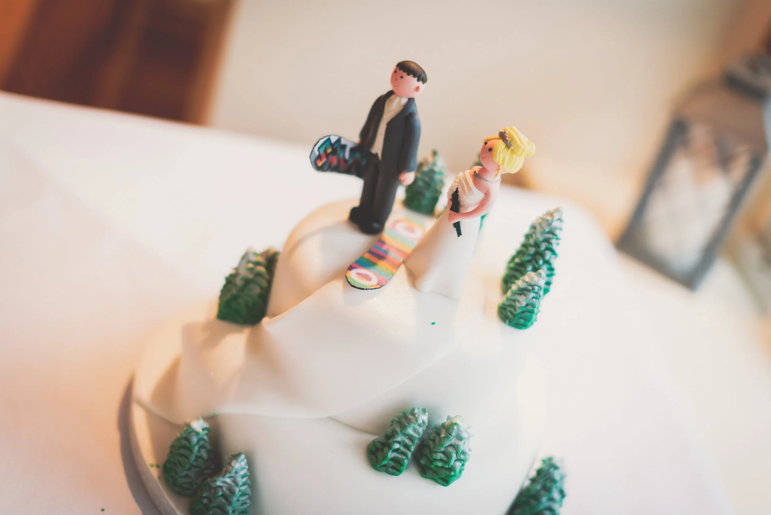 Wedding Cake with snowboard decorations of Bride and Groom in wedding near Bristol