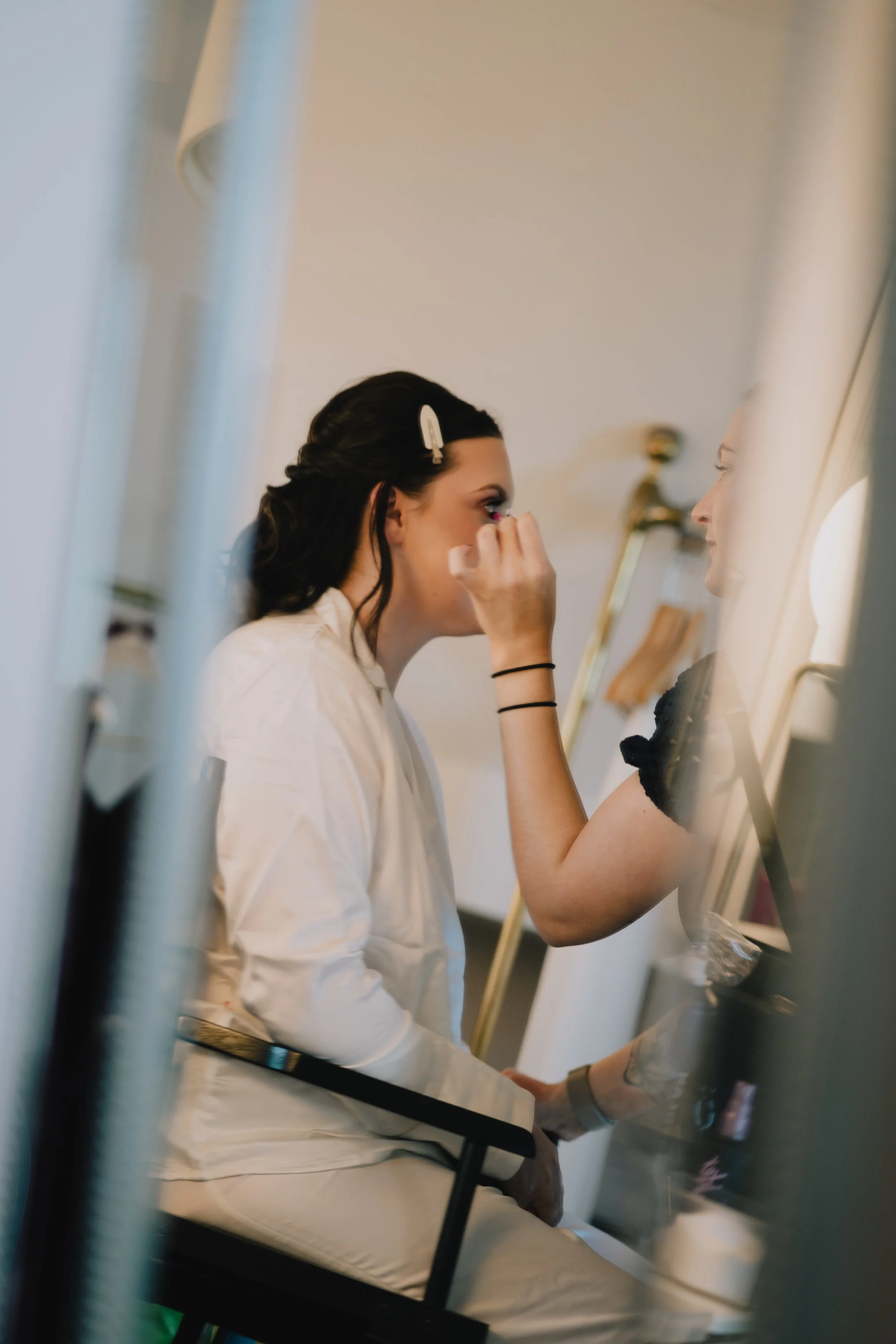 A bride getting her makeup done by a makeup artist during bridal prep at Pear Tree Purton