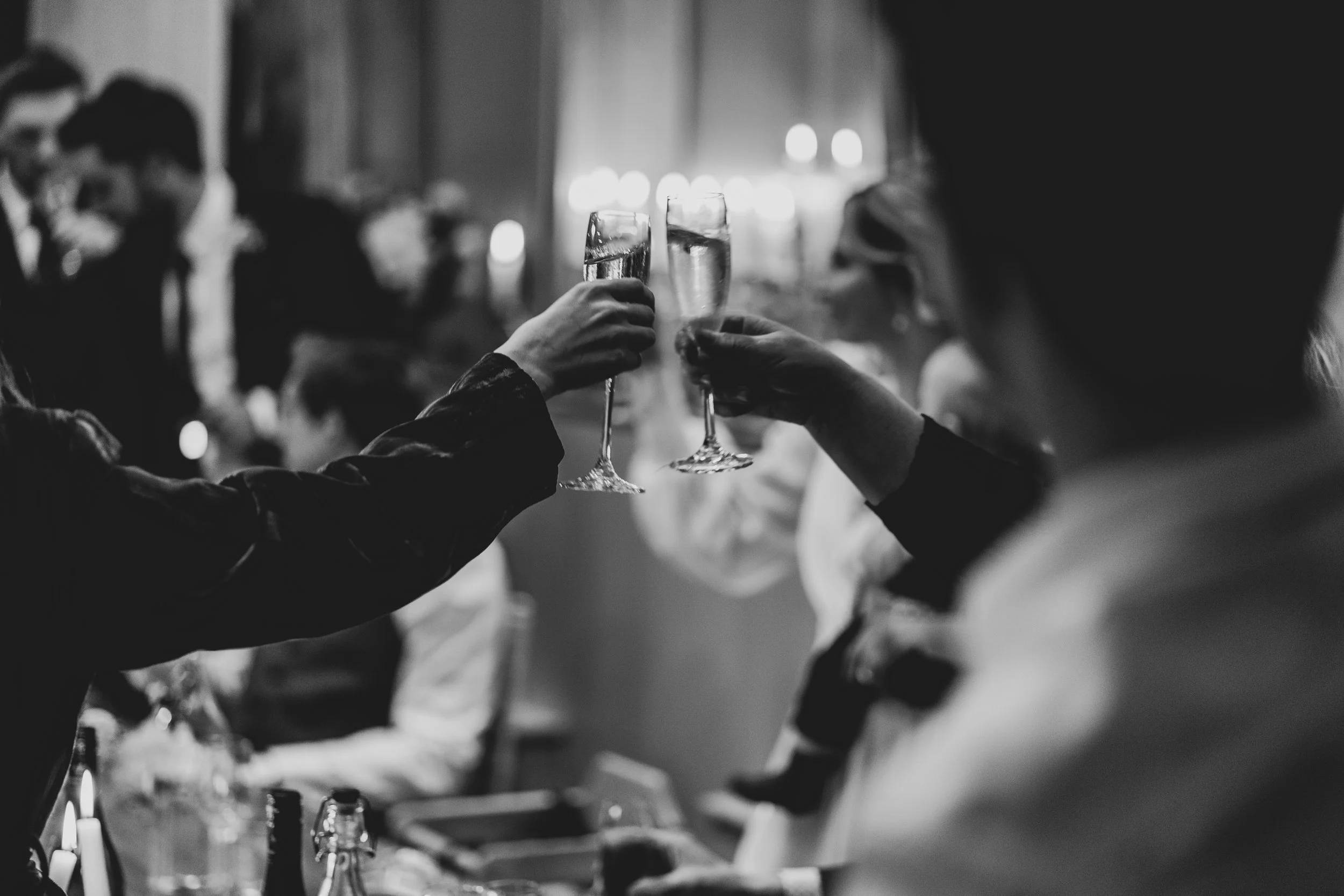 Champagne glasses being clinked captured by relaxed bristol wedding photographer