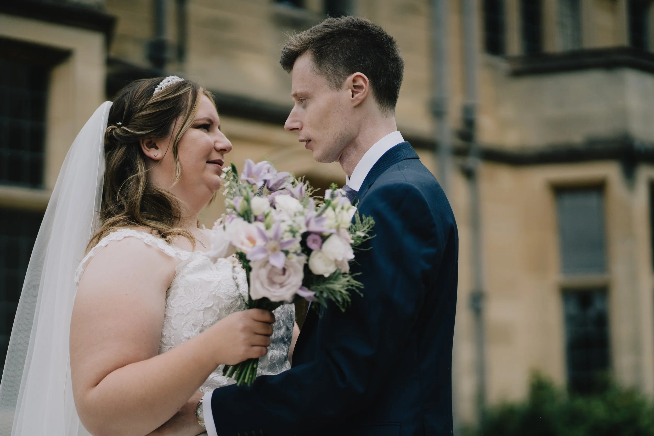 Bride and groom holding flowers outside Coombe Lodge taken by Bristol Wedding Photographer