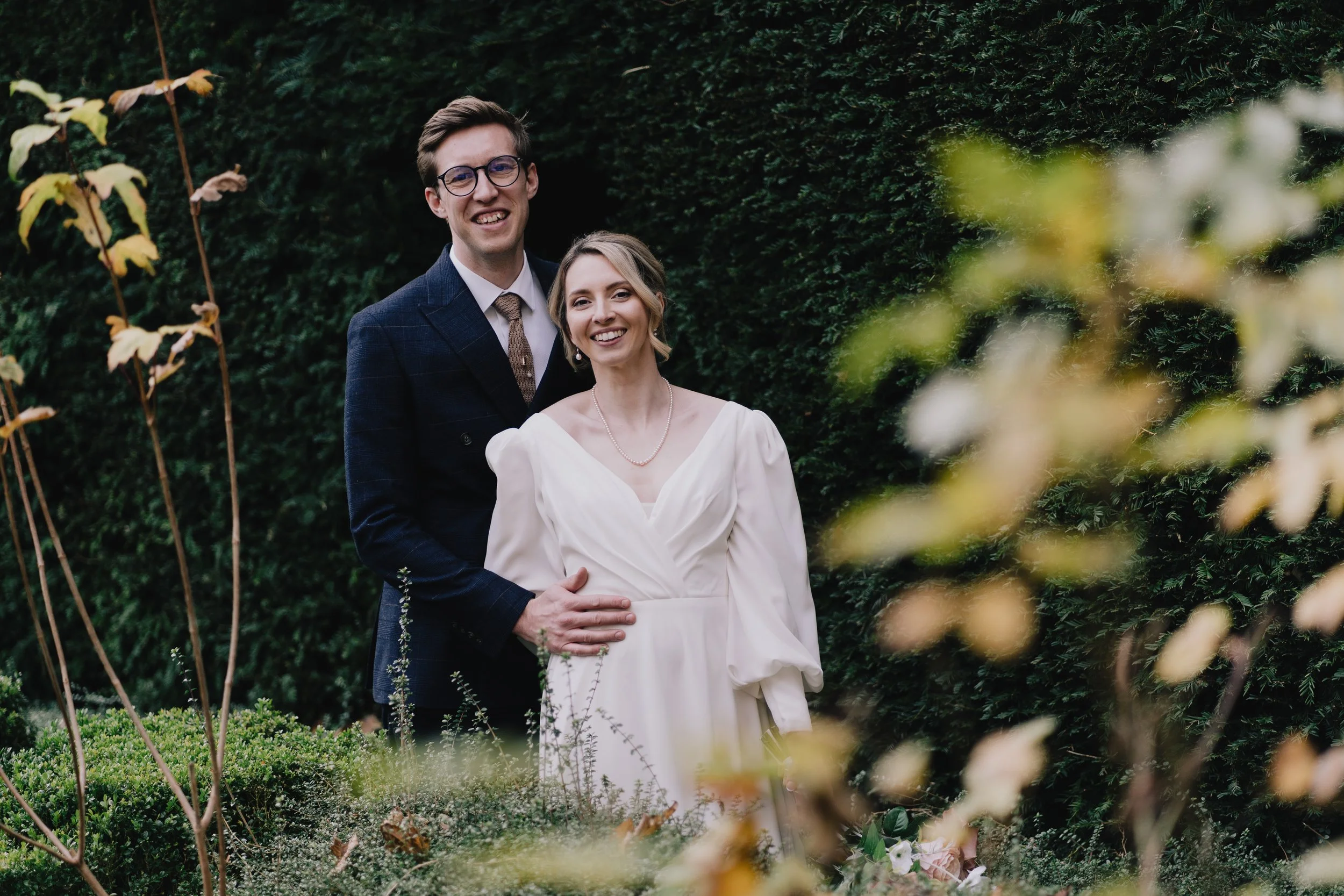 Relaxed couple portrait of bride and groom in Owlpen Manor gardens