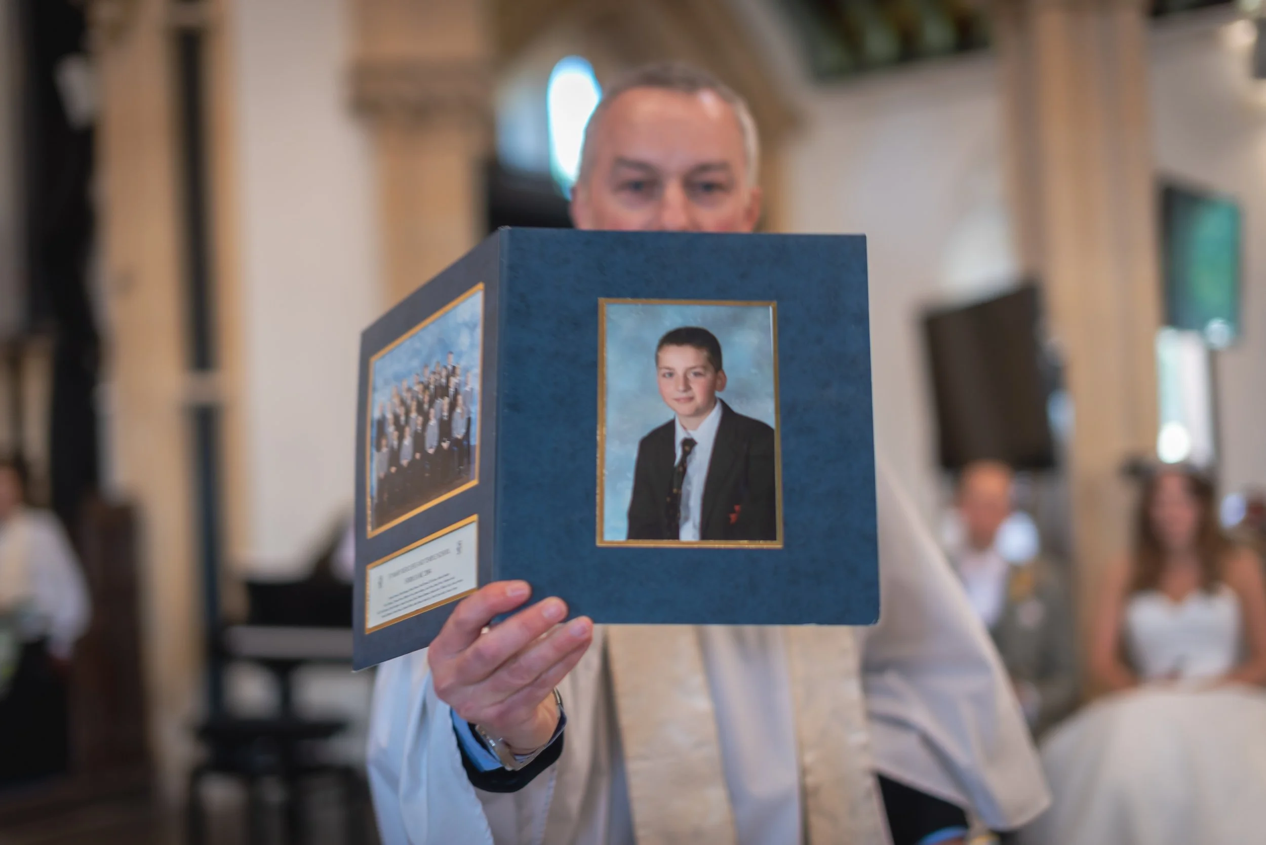 Documentary Wedding Photographer in Bristol capturing vicar holding embarrassing photo of groom during service