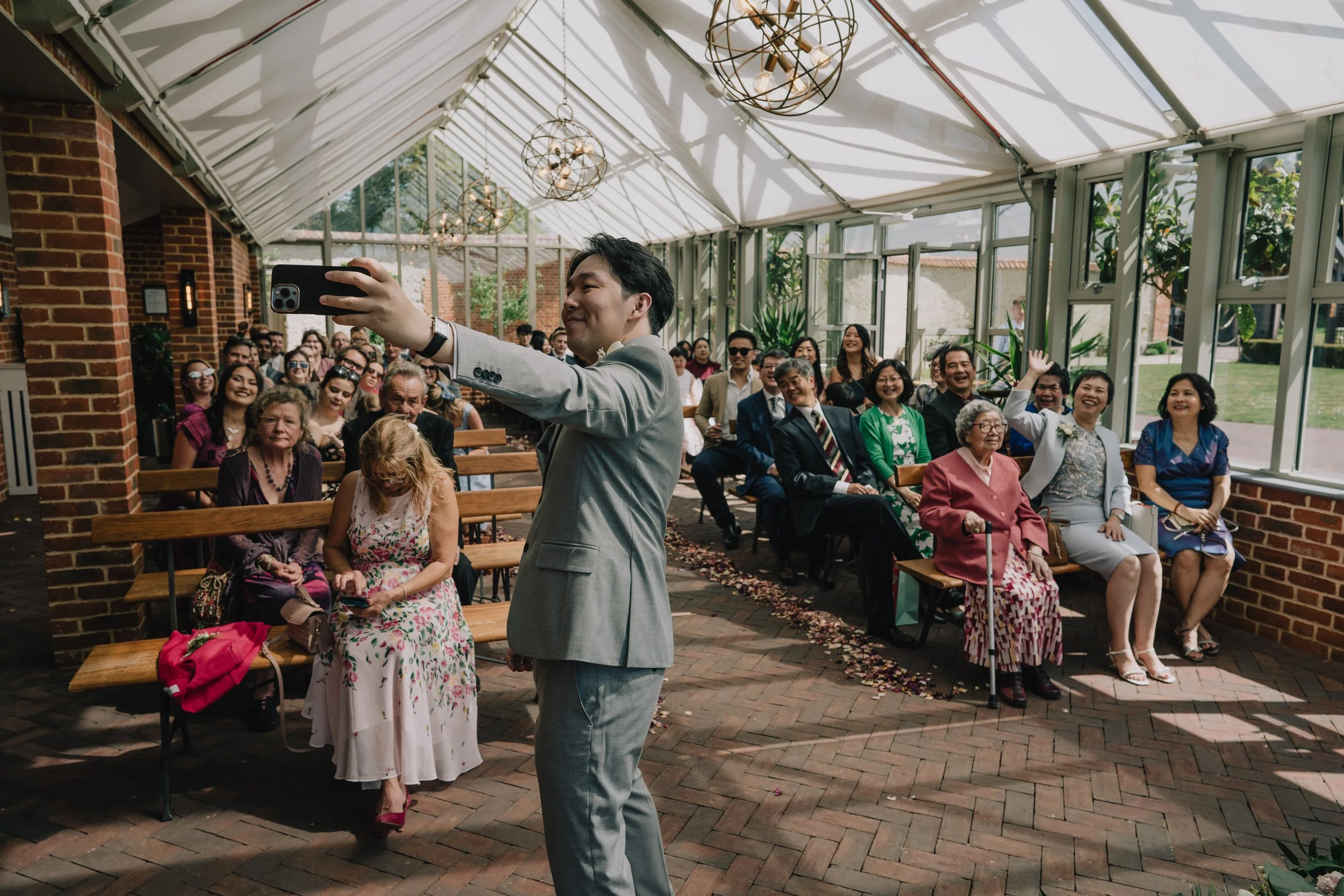 Groom Kevin taking a joyful selfie with wedding guests before ceremony at Syrencot