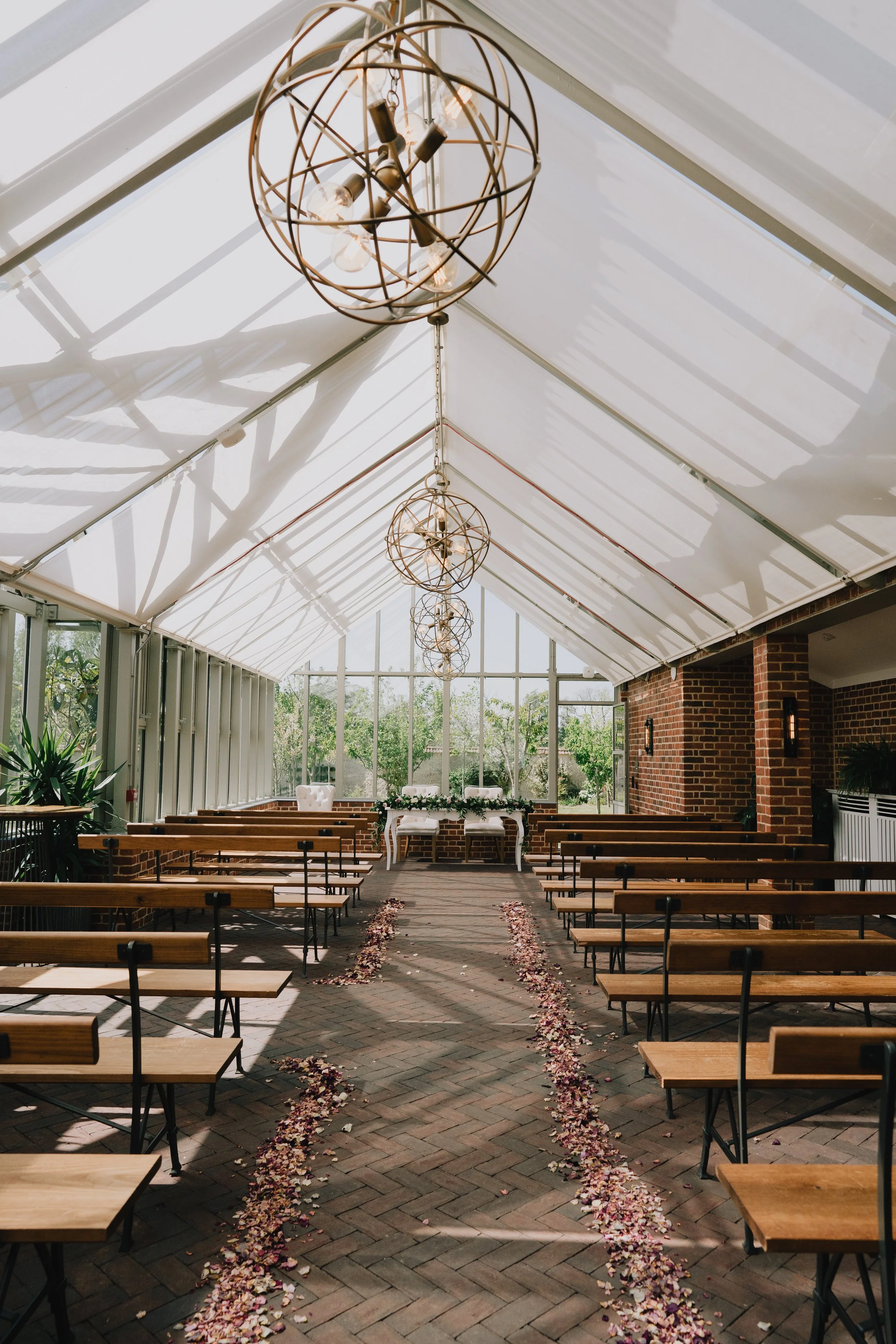 Empty Glasshouse at Syrencot, ready for wedding ceremony with natural light and greenery