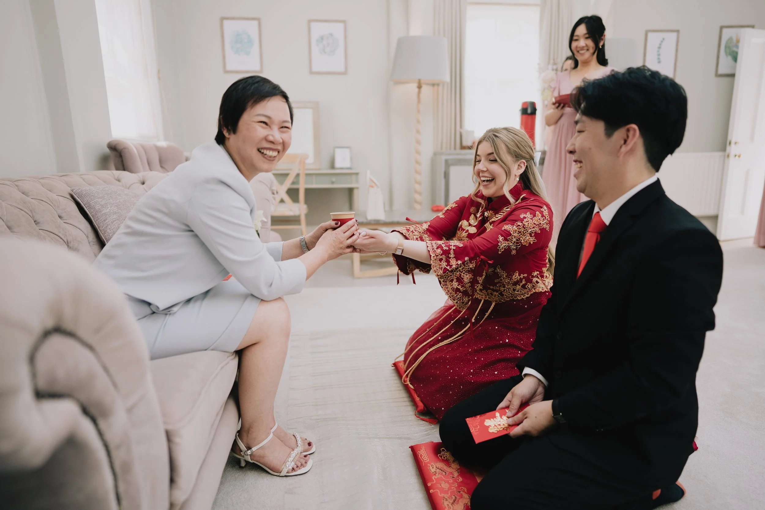 Lucy and Kevin laughing together while receiving gift in Chinese tea ceremony at Syrencot