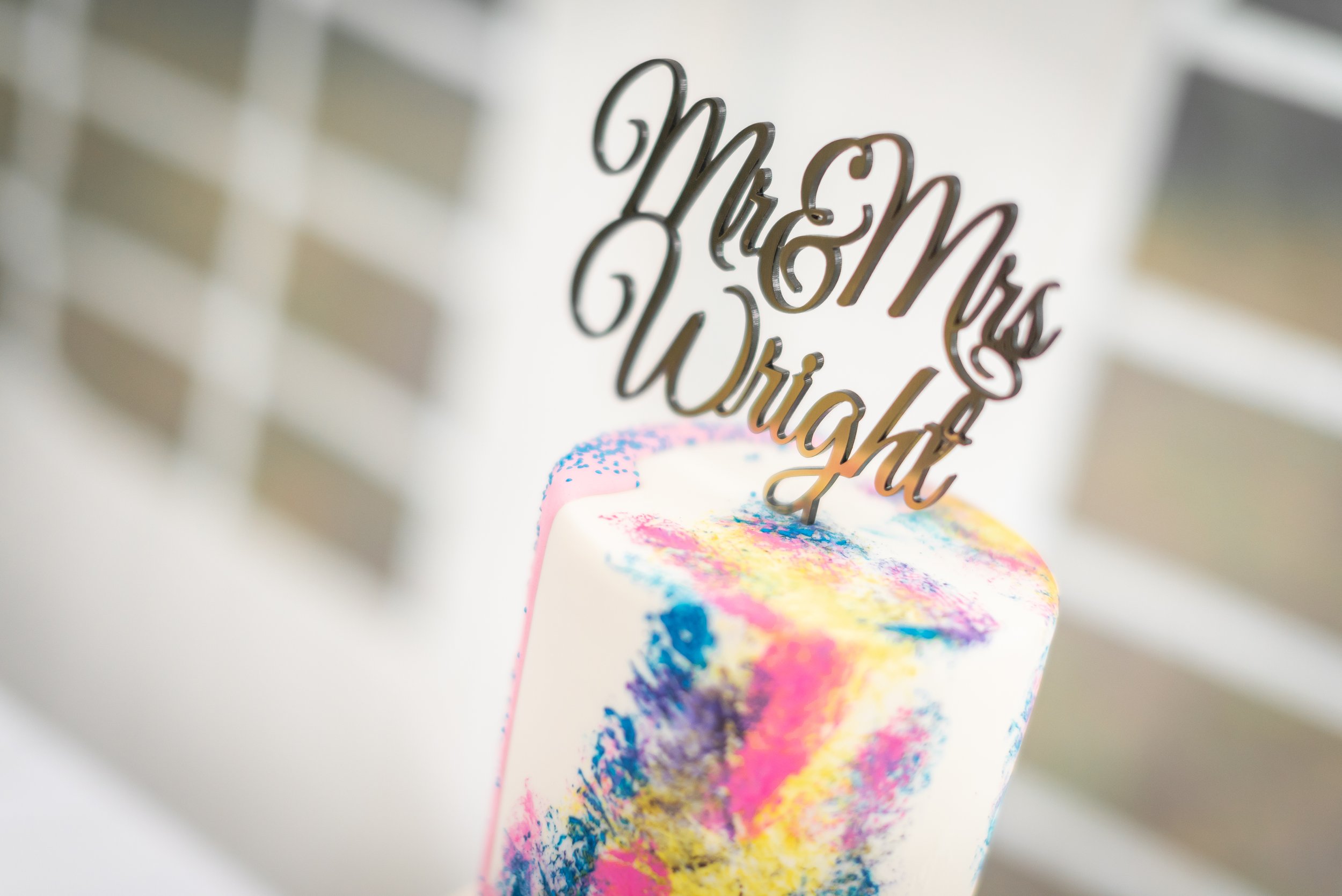 A colorful cake with a "Mr & Mrs Wright" cake topper during Bristol wedding.