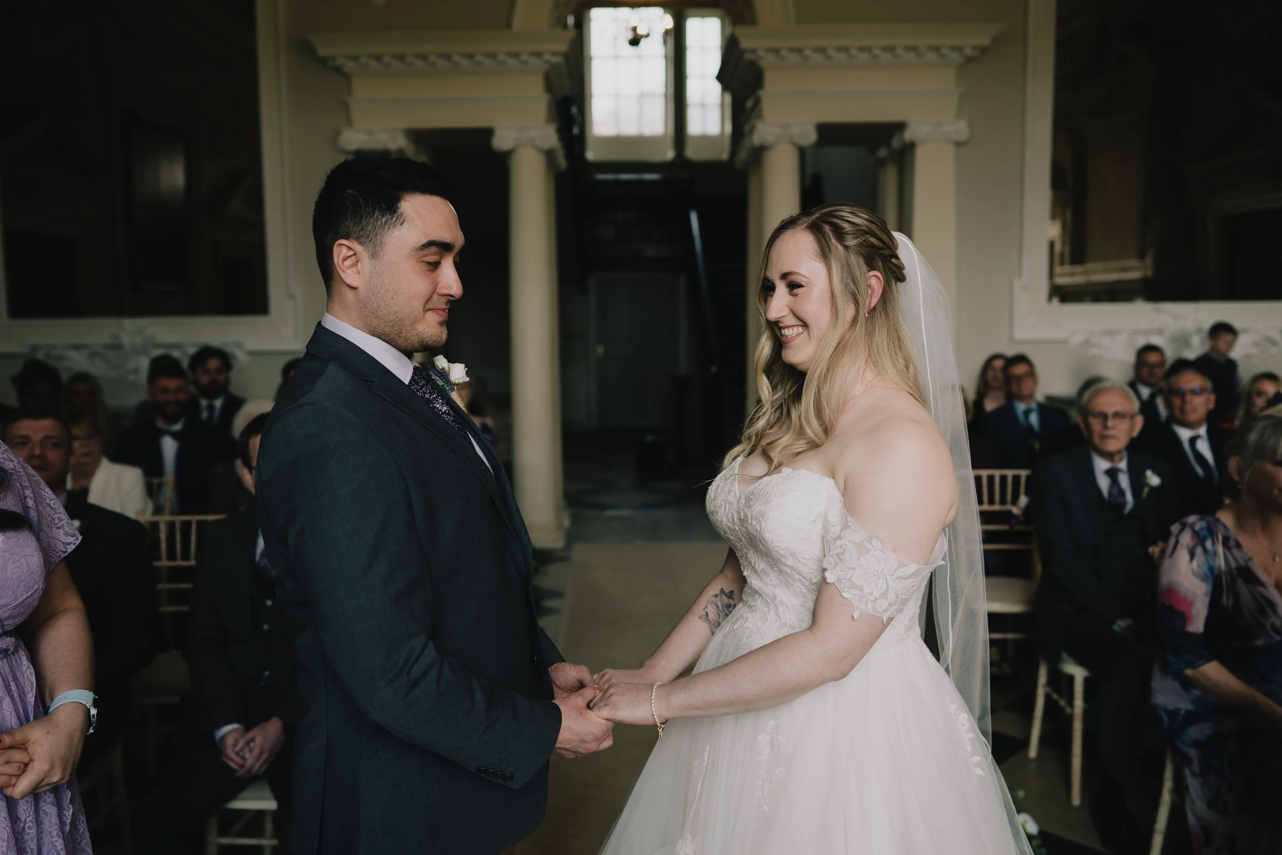 Bride and groom holding hands at the top of the aisle during emotional wedding ceremony at Crowcombe Court, Somerset.
