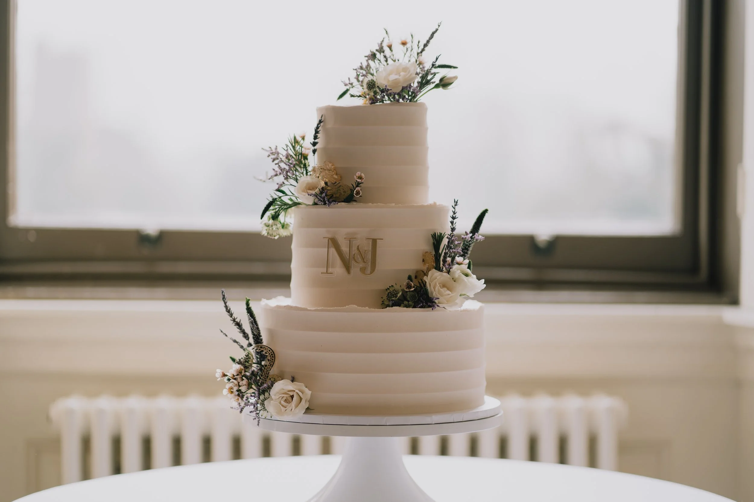 Elegant wedding cake with floral detail on display at Crowcombe Court wedding reception at Crowcombe Court in Somerset.