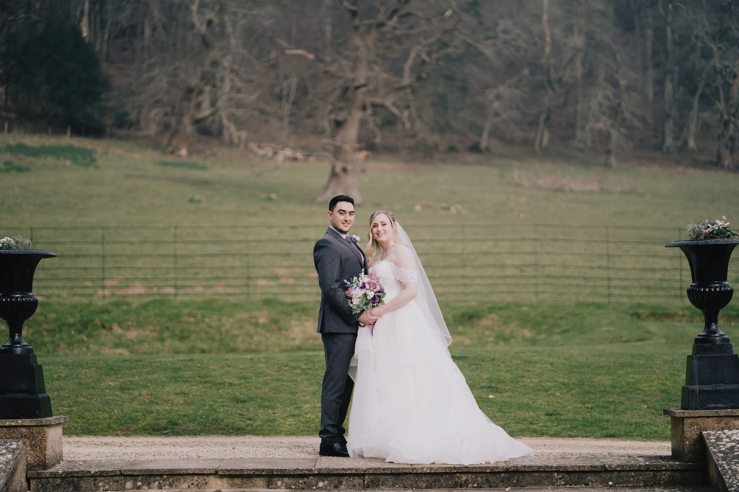 Romantic moment of bride and groom embracing in the manicured gardens at Crowcombe Court wedding venue.