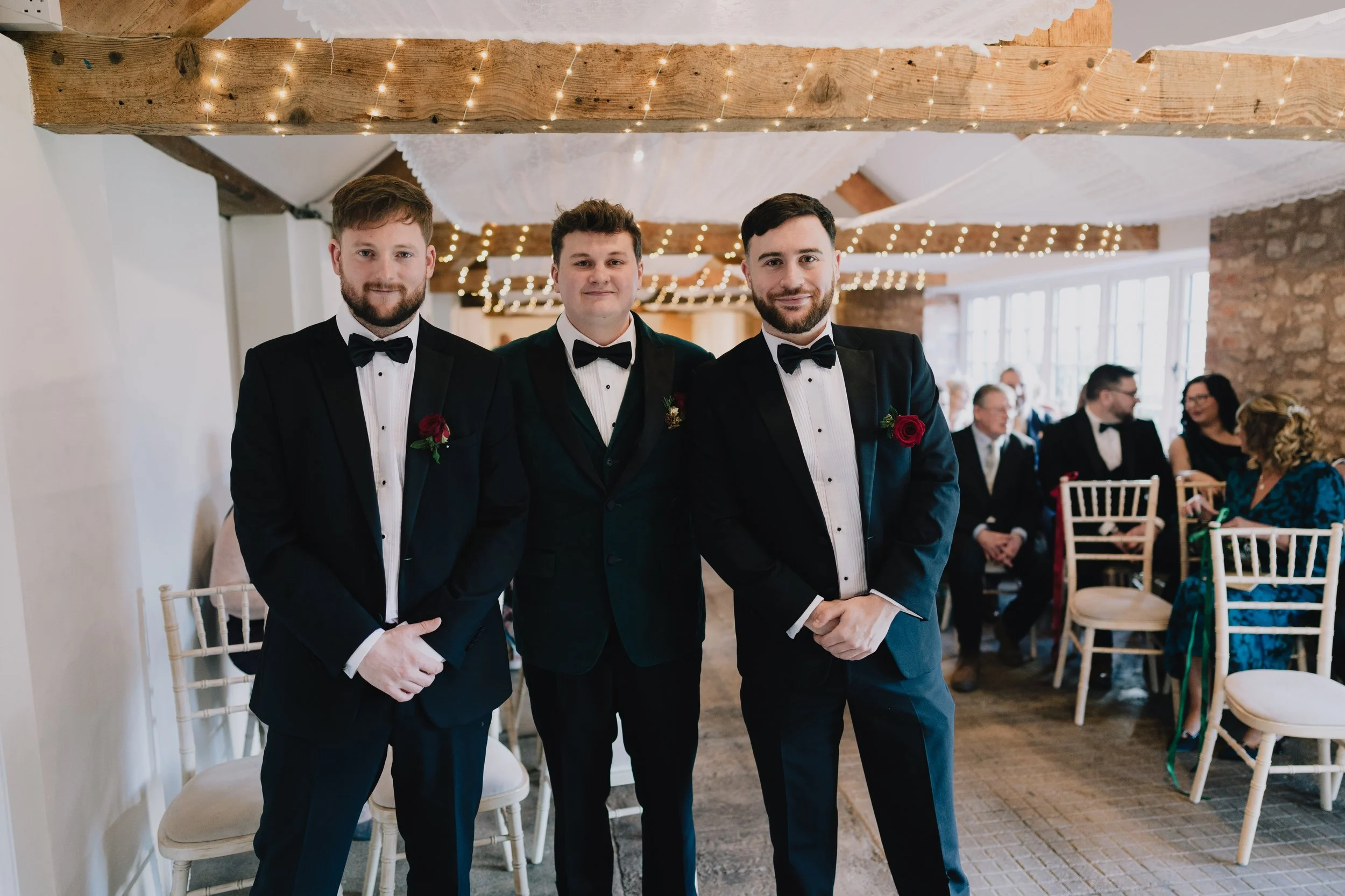 Groom and best men waiting at top of aisle during wedding ceremony at Quantock Lakes, Somerset