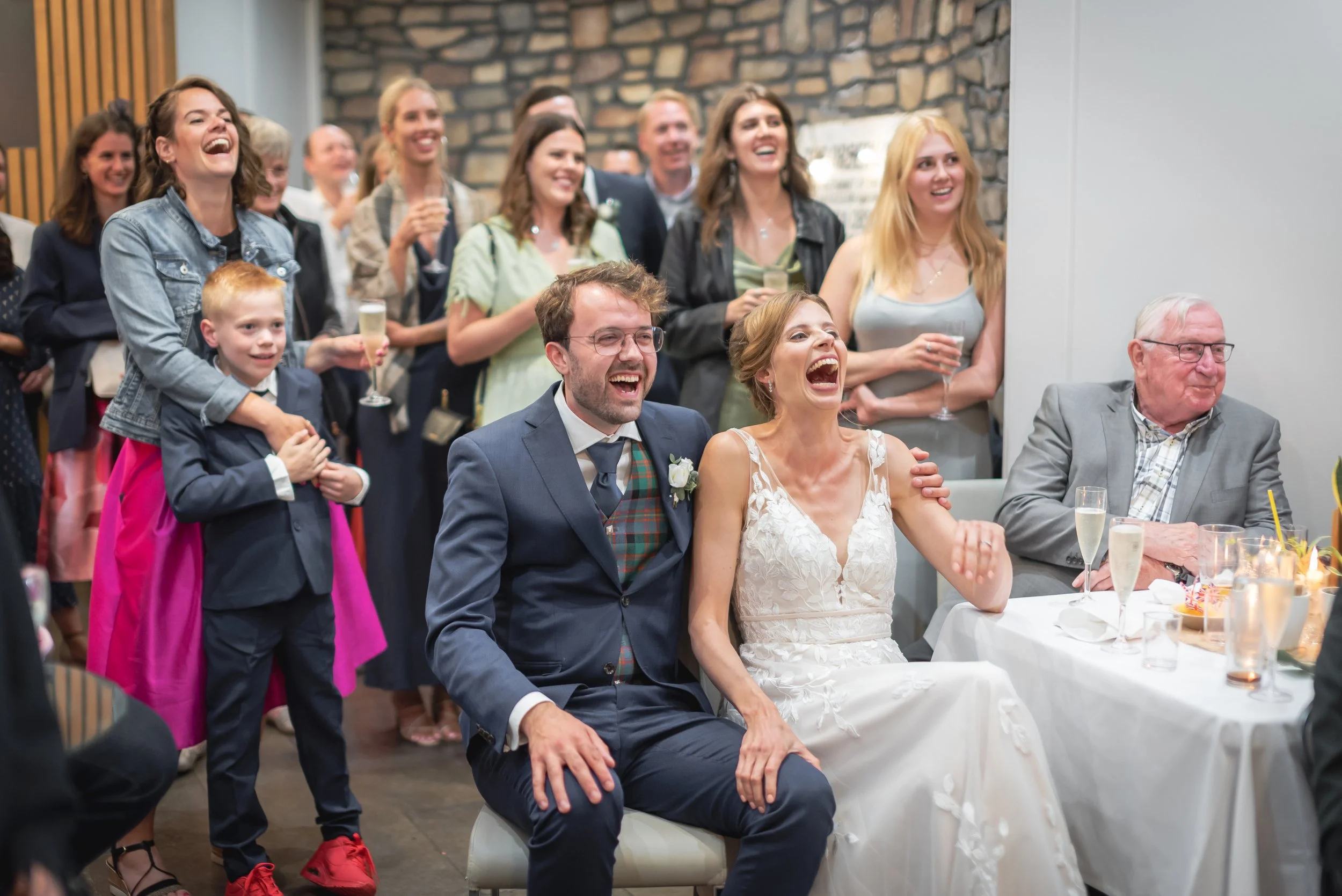 Candid moment of bride and groom laughing during the best man speech at their Clifton Observatory wedding reception.