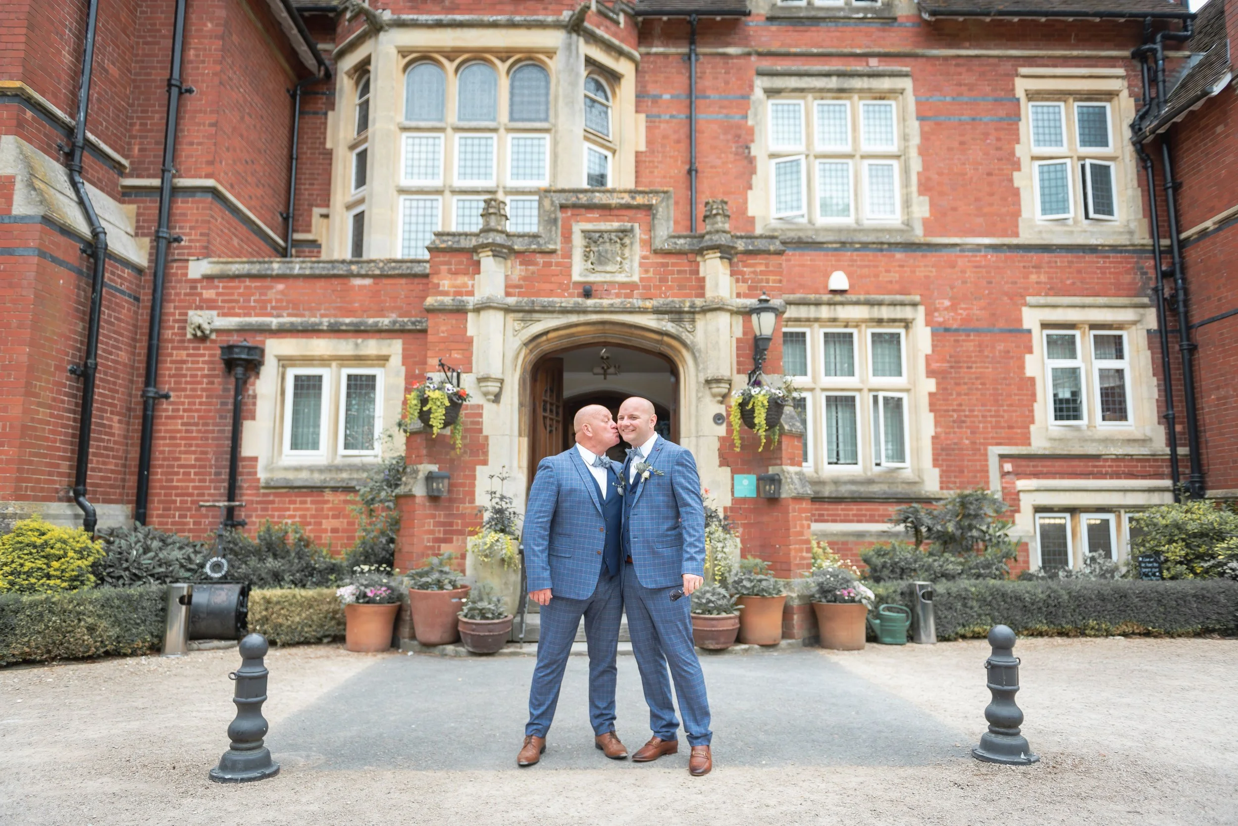 Grooms kissing outside Berwick Lodge
