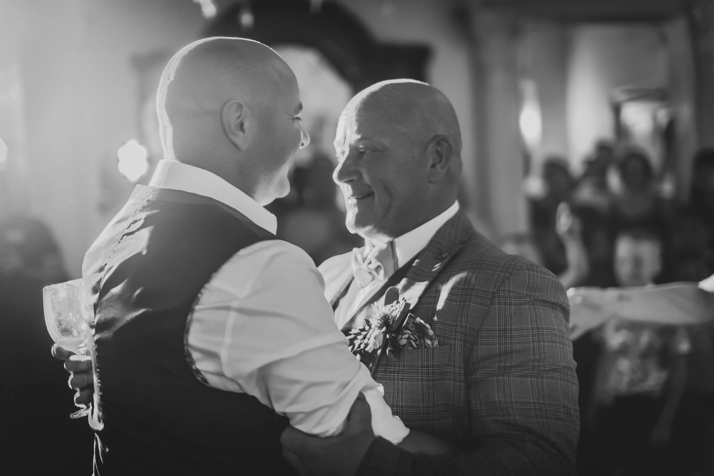 2 grooms dancing during first dance in monochrome black and white image at Berwick Lodge