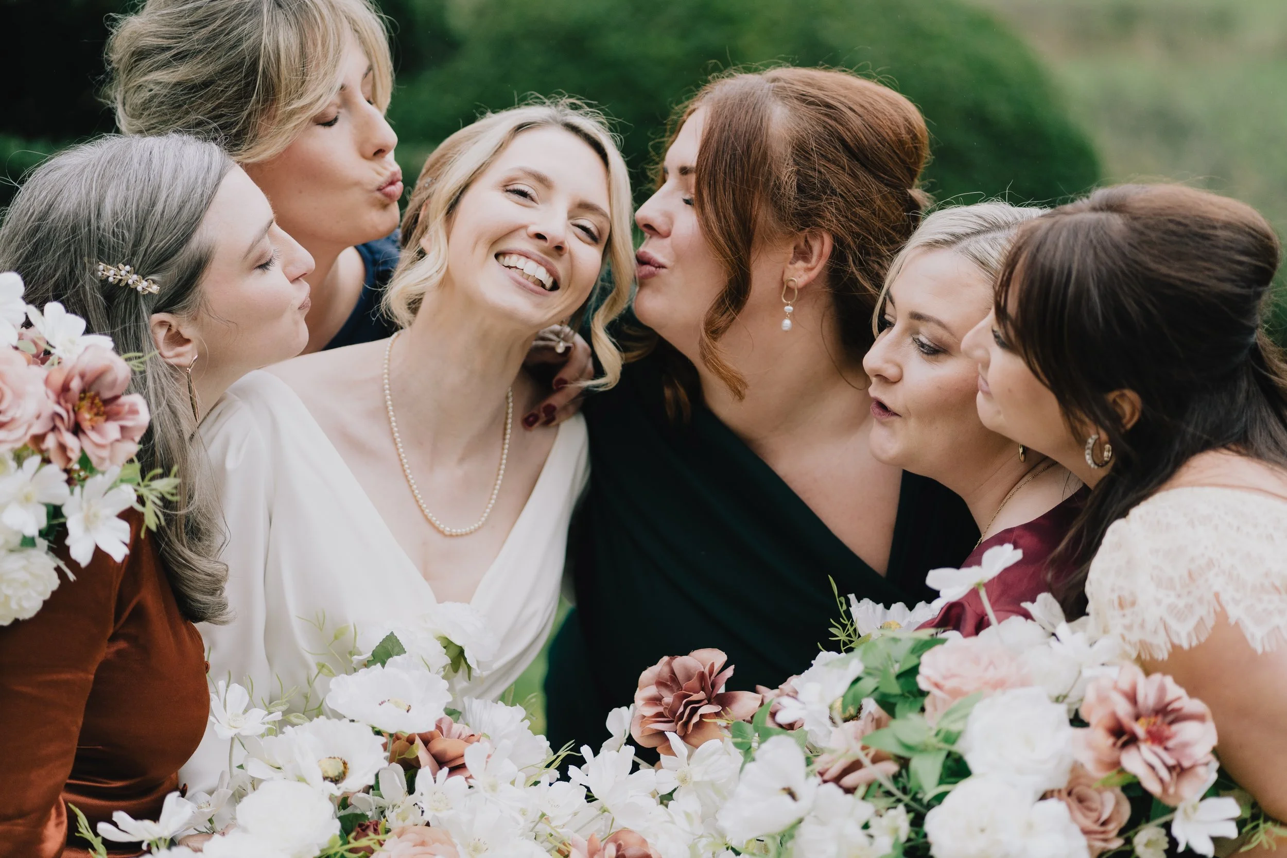 Bride and Bridesmaid posing with flowers captured by Natural Bristol Wedding Photographer