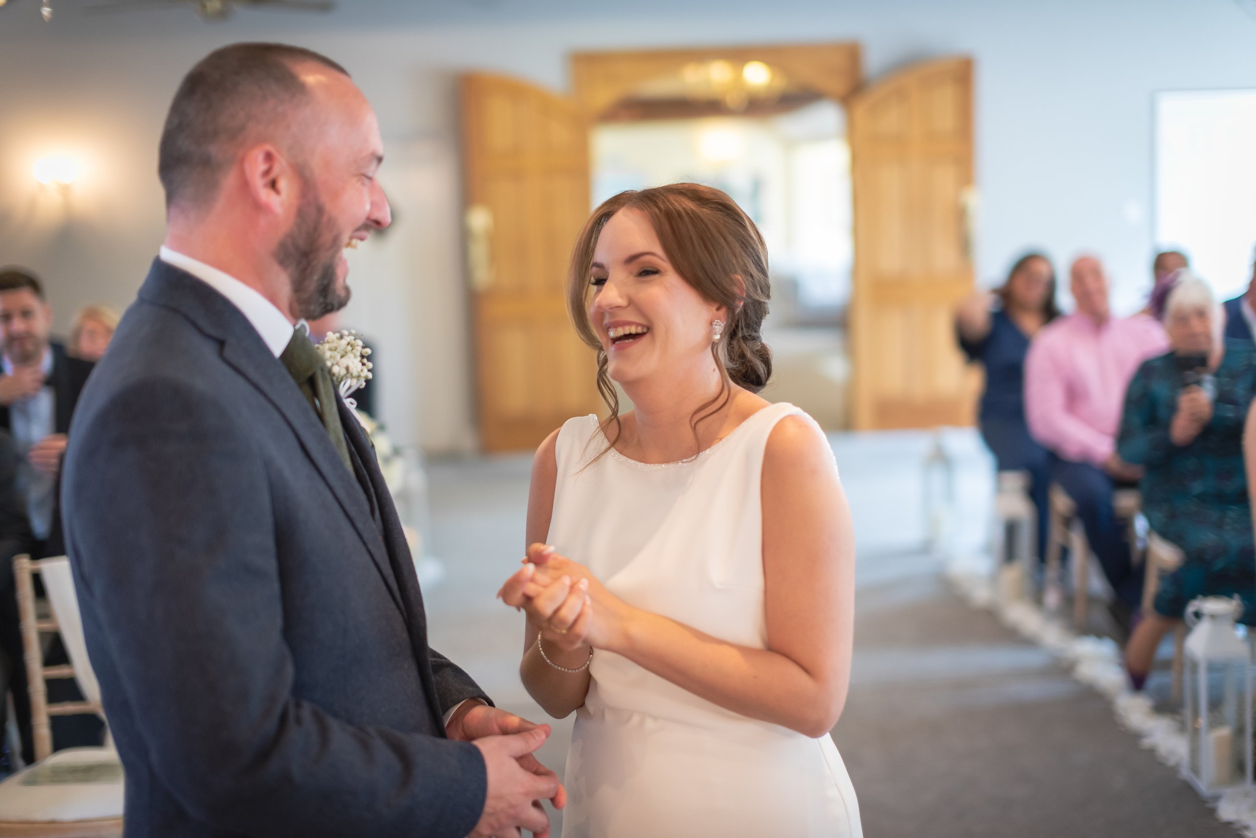 Bride laughing with the groom at the top of the aisle at Batch Country House
