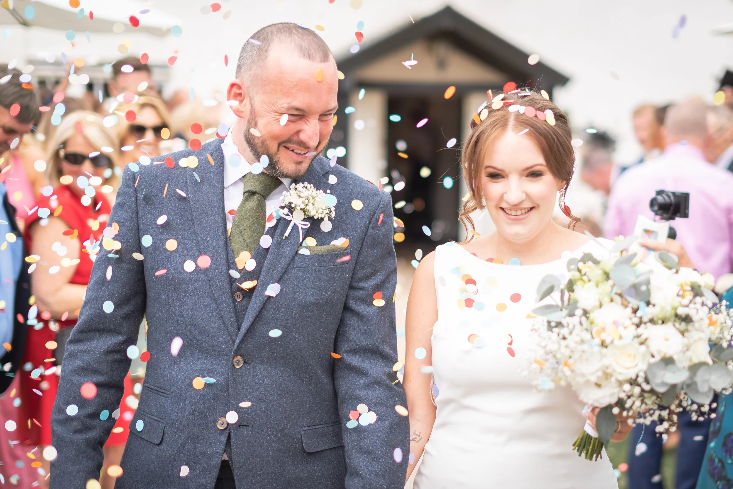 Confetti throw at Batch Country House with bride and groom getting covered in floral decorations