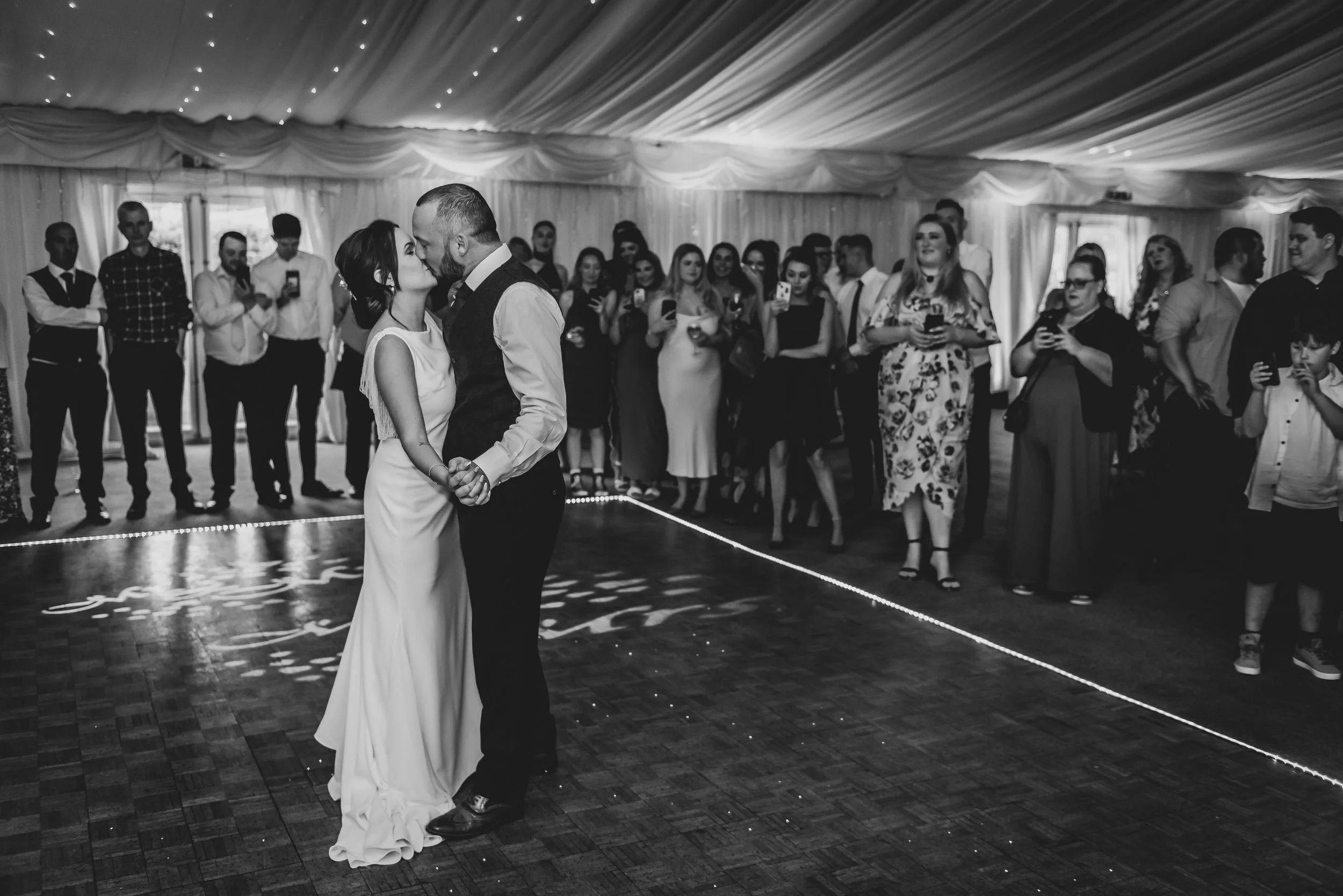 Bride and Groom dancing with eacother under the lights in black and white at Batch Country House