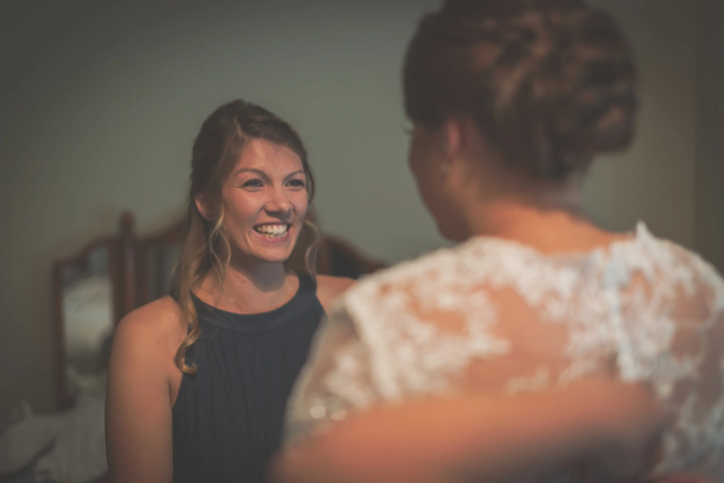 Bridesmaid really happy and smiley after seeing the bride ready