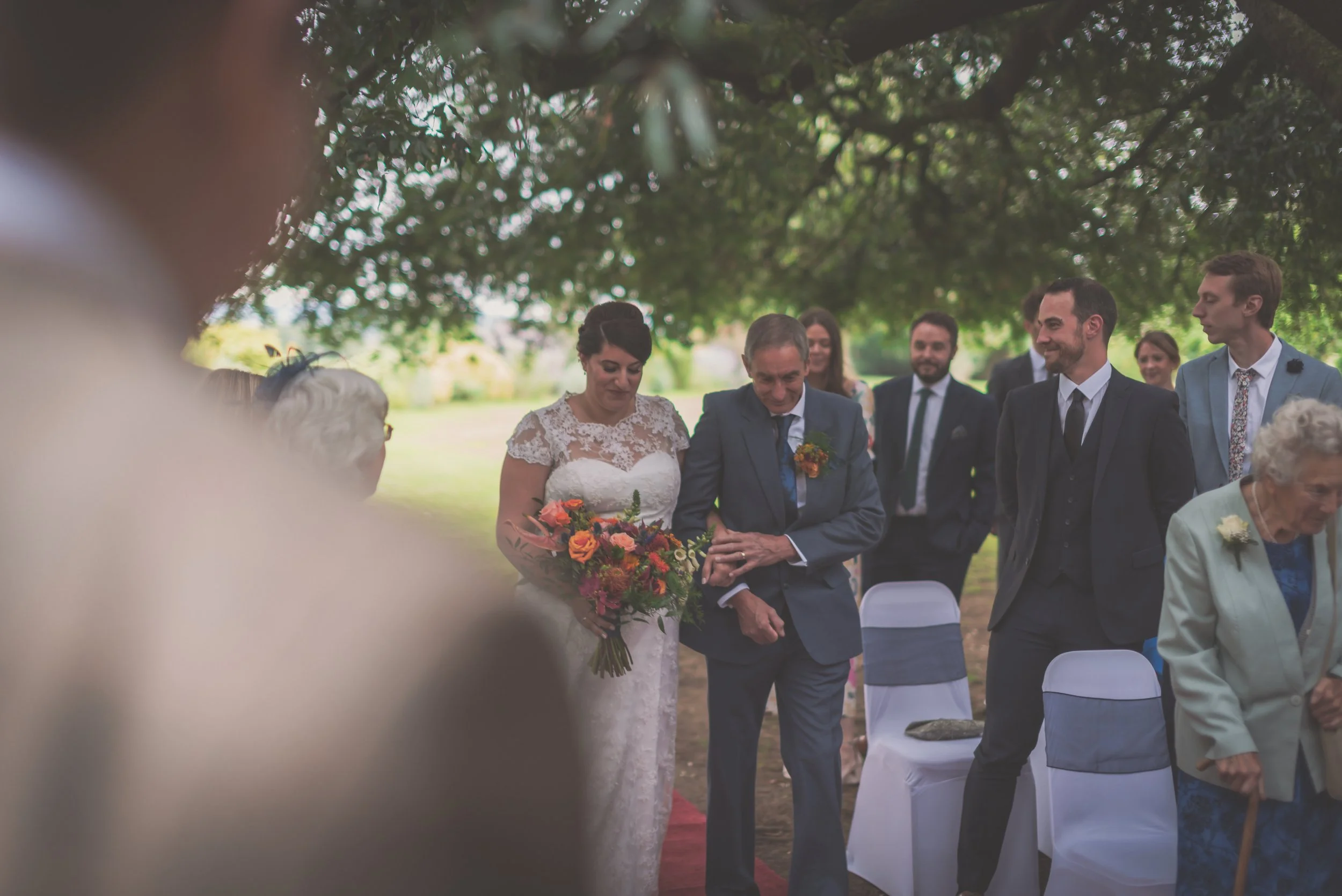 Bride walking down the aisle with groom on looking at Aldwick Estate