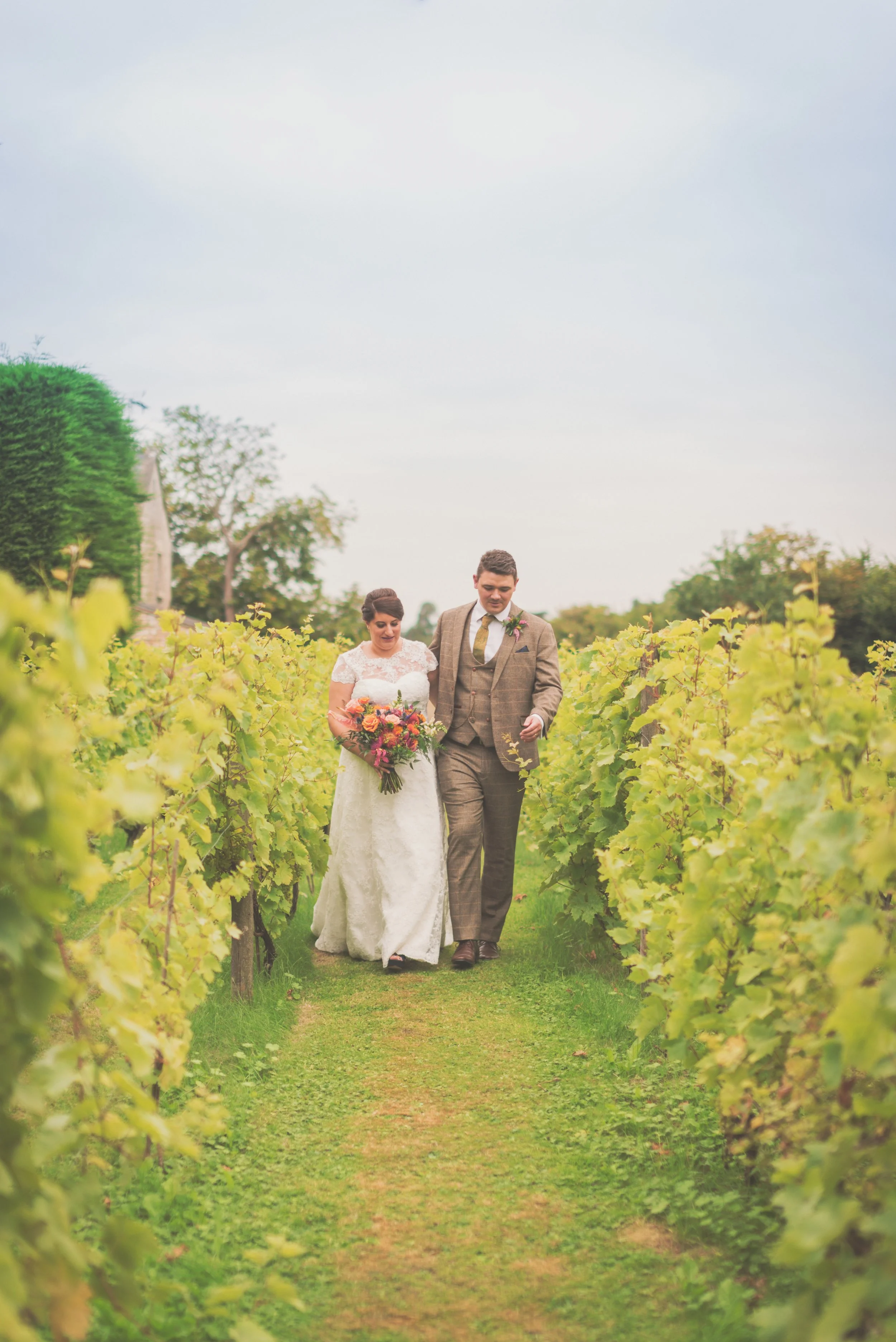 The married couple linking arms walking towards camera at Aldwick Estate