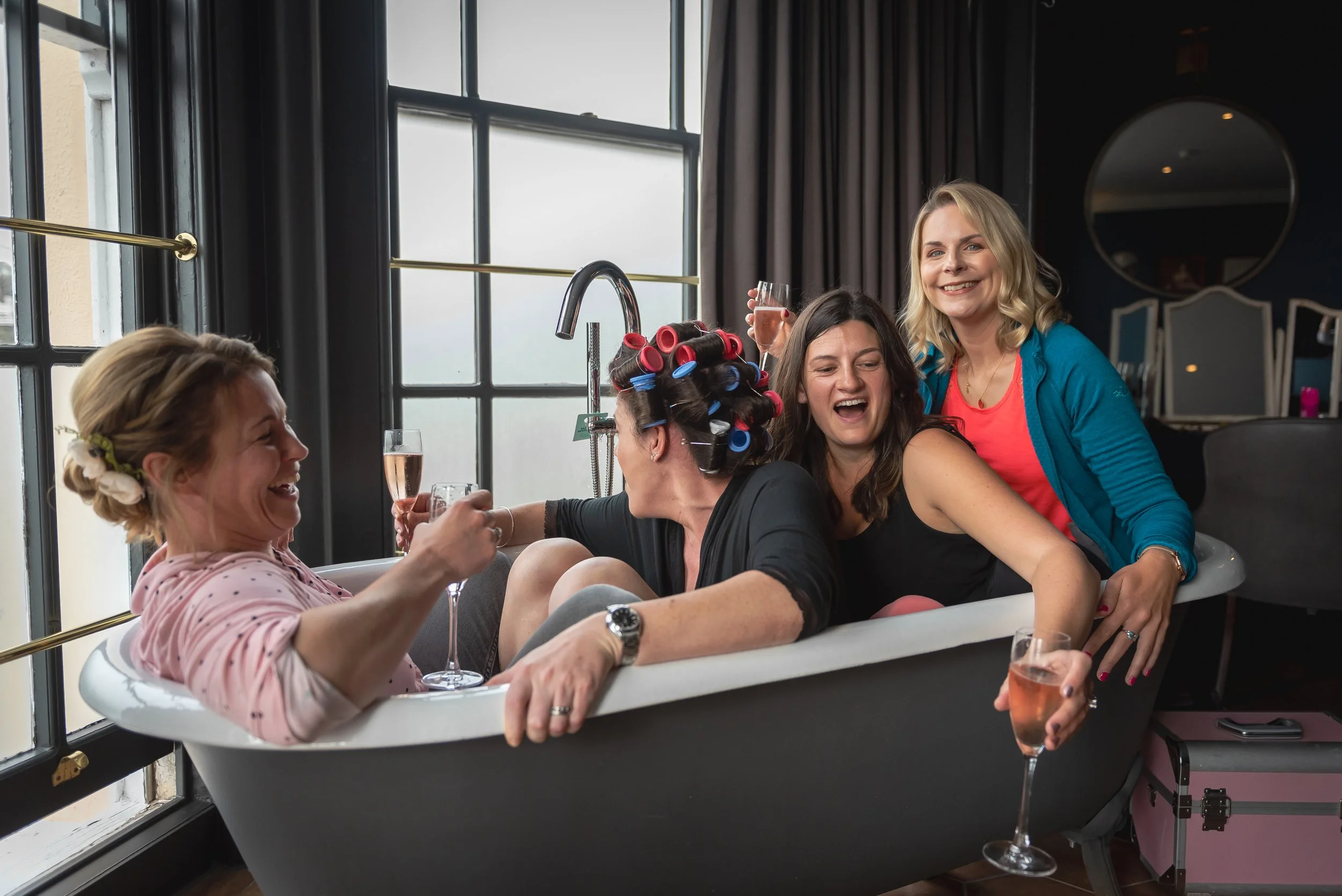 Bridesmaids laughing and enjoying champagne on the wedding morning