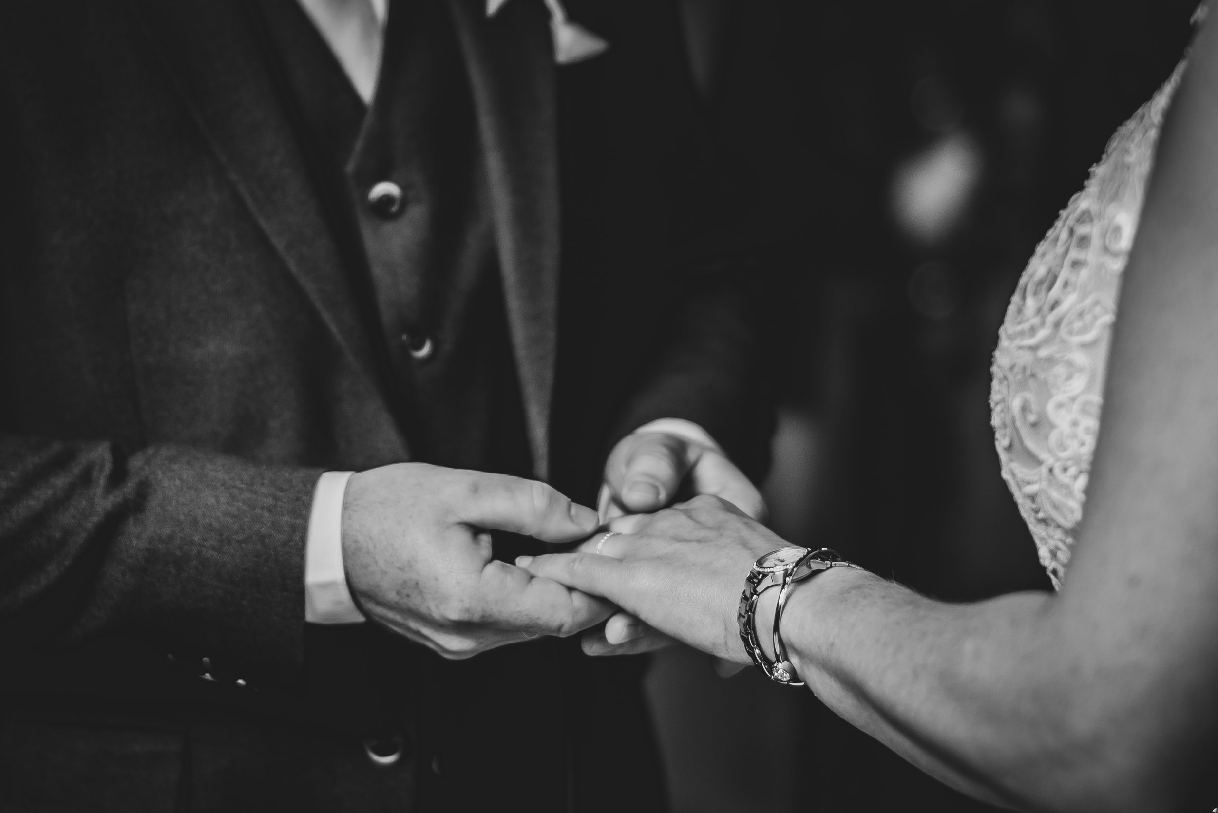 Groom placing wedding ring on bride’s finger during ceremony