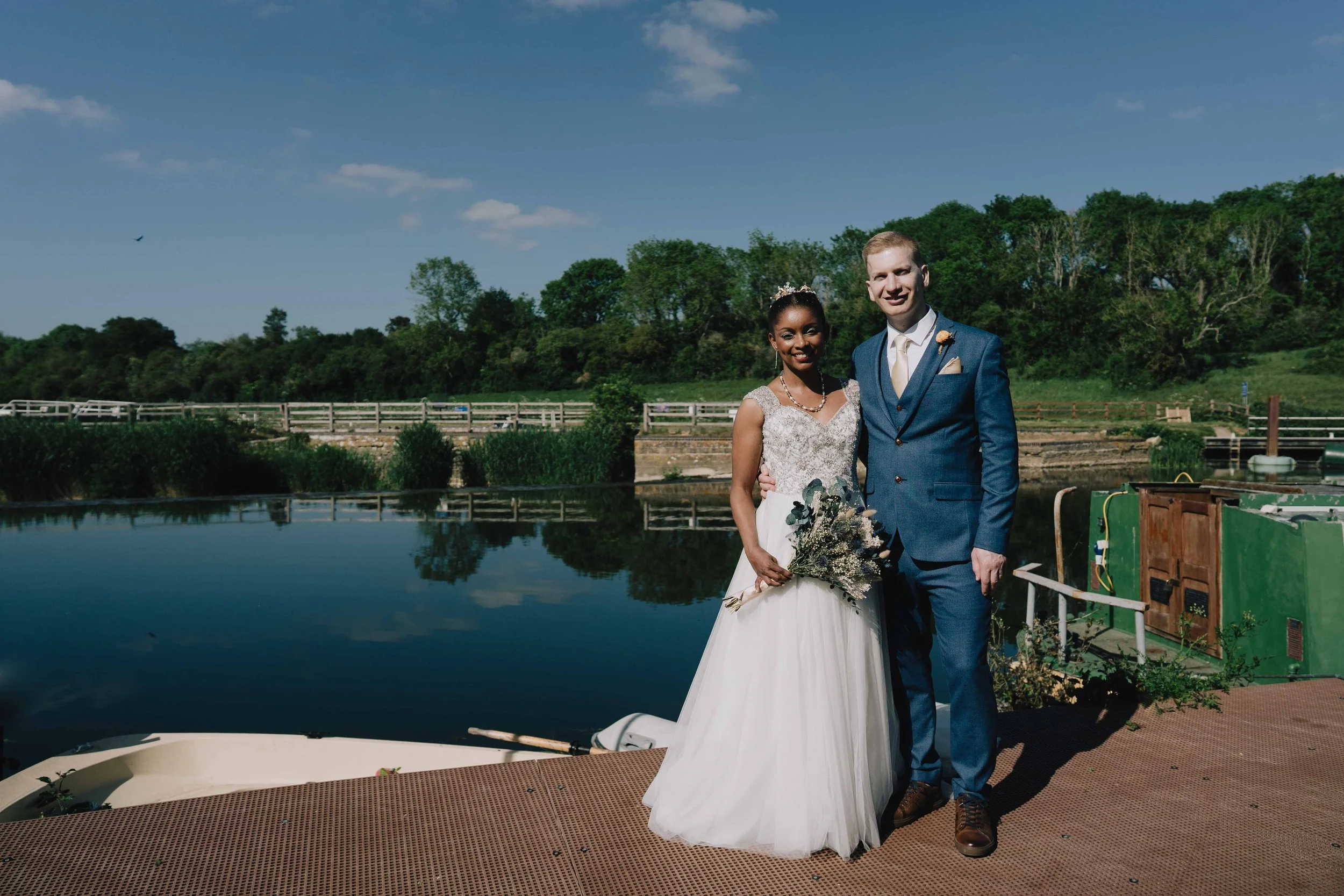 Bride and Groom posing for photo during relaxed candid session after their wedding ceremony at Riverside Inn in Salford by wedding photographer in Bristol
