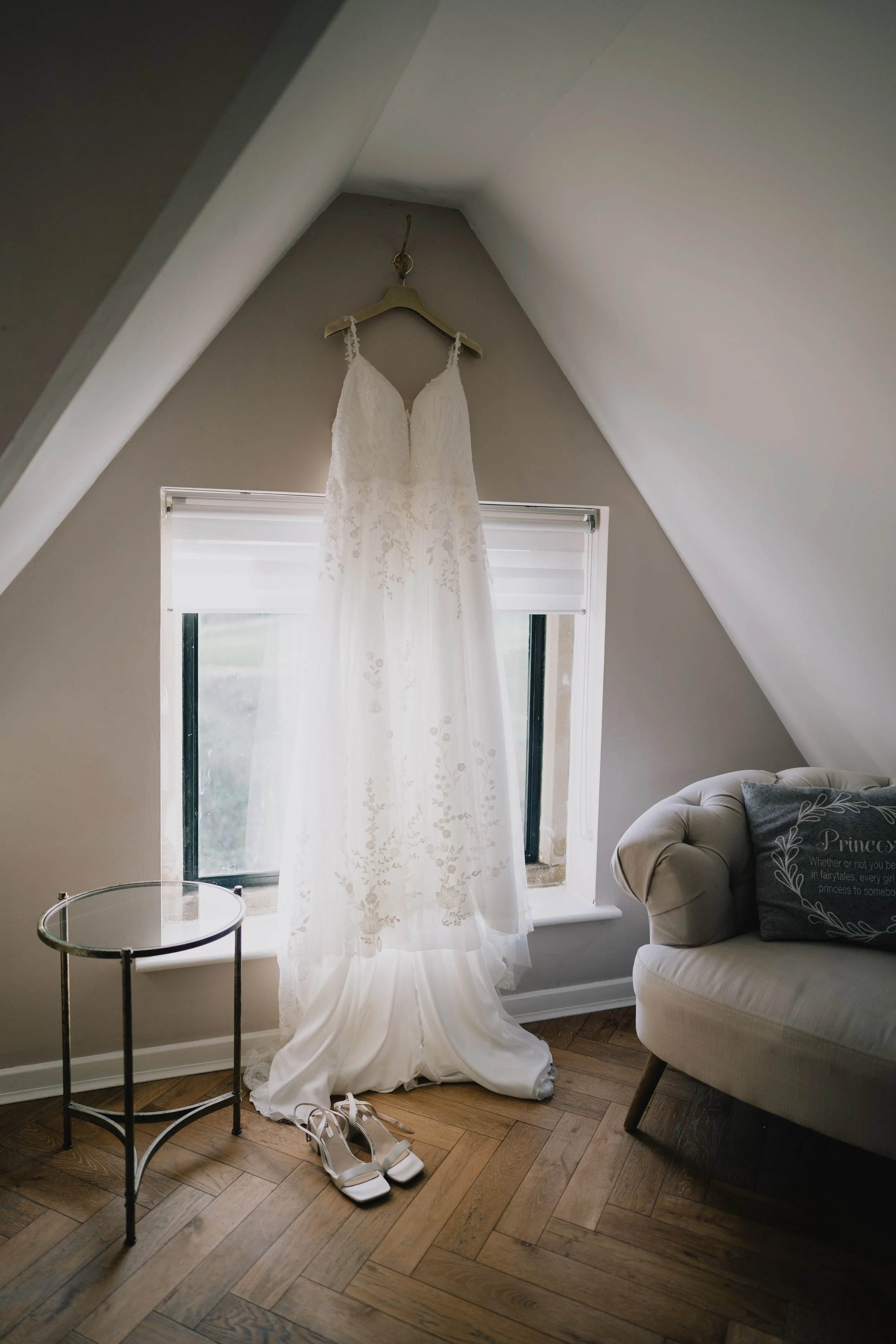 Brides Wedding Dress hung up with wedding shoes at The Pear Tree in Purton in the bridal suite