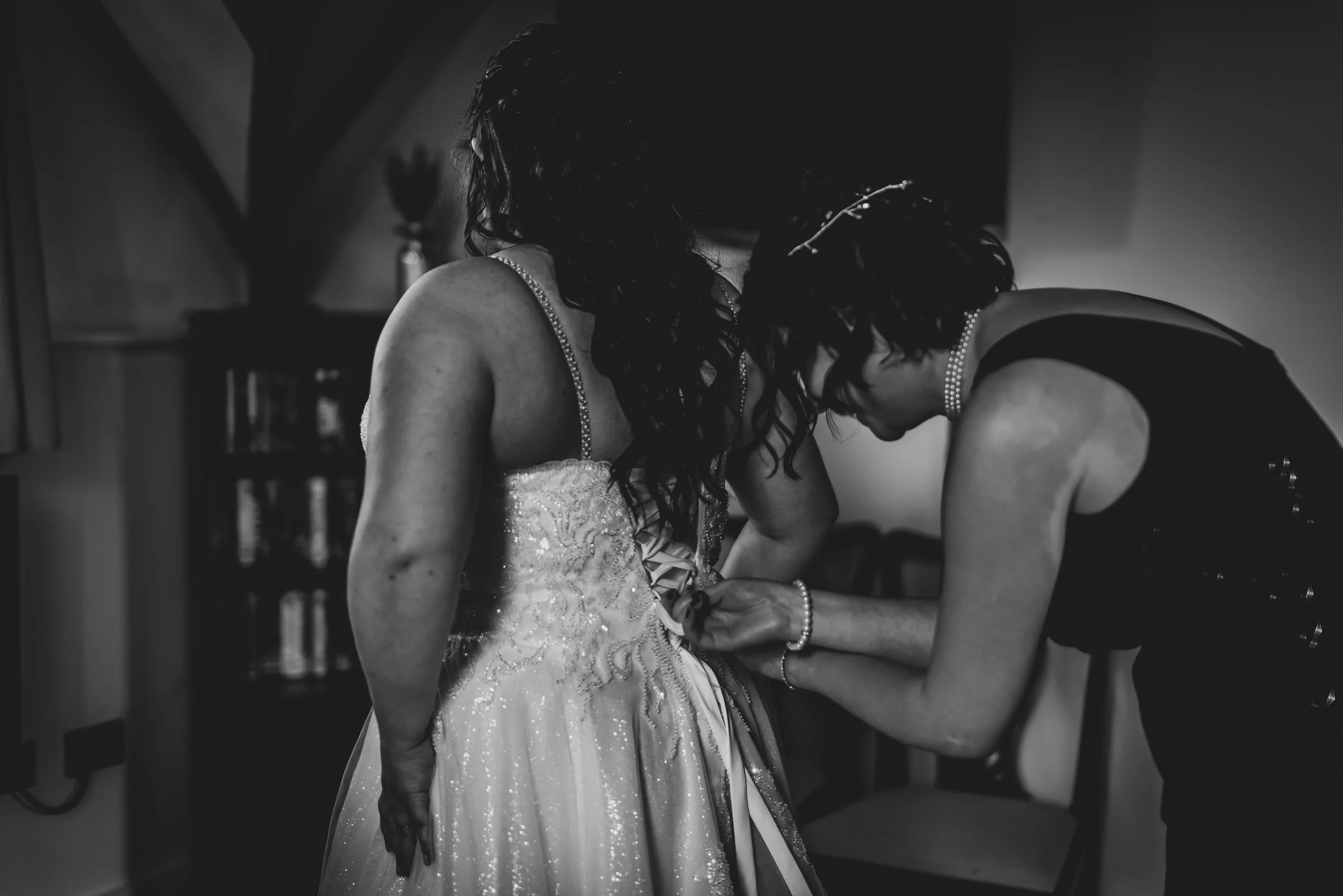 Bride having dress done up before her wedding at Deer Park Hall
