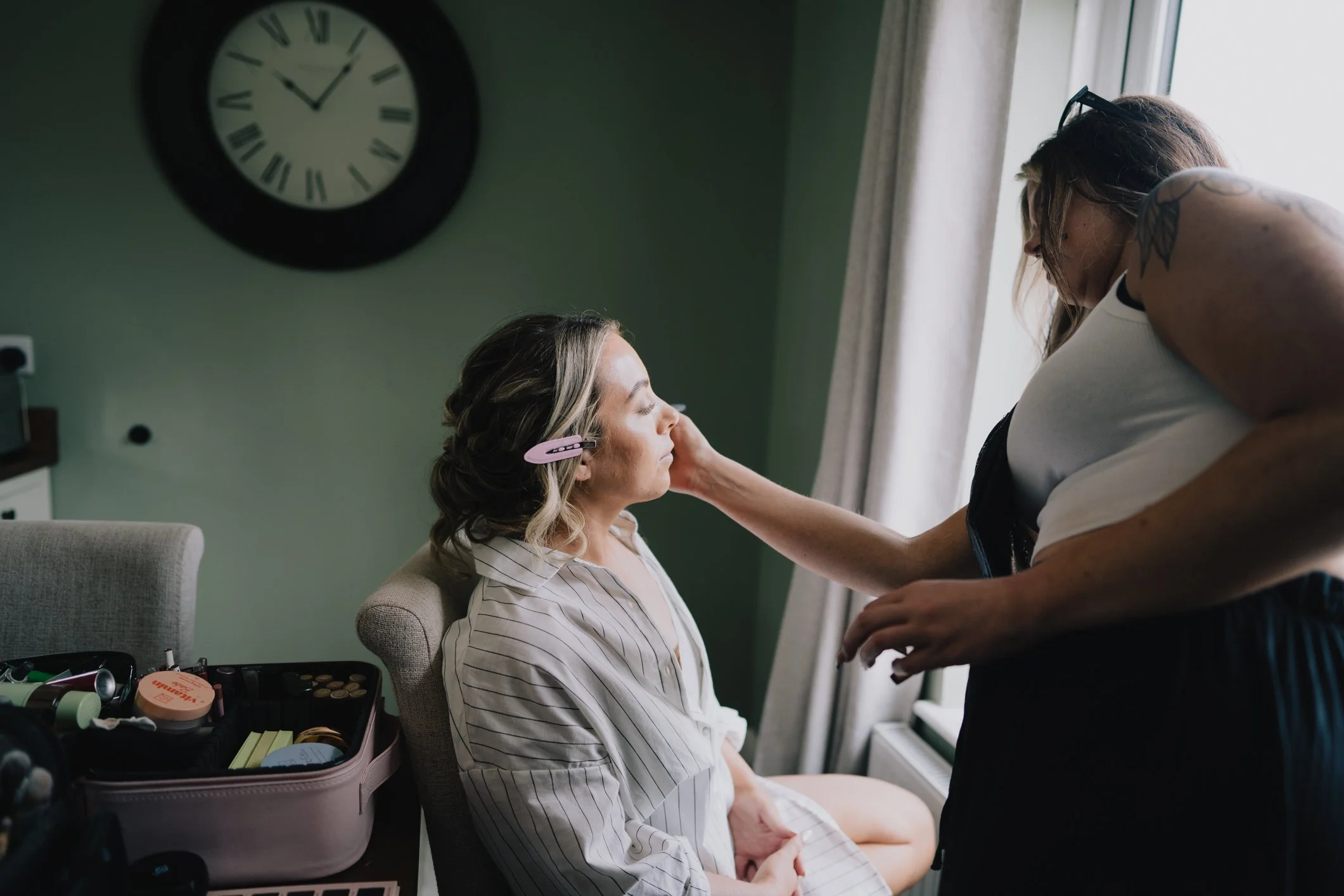 Bride having make-up done at home, natural candid moment during morning bridal preparations in Somerset